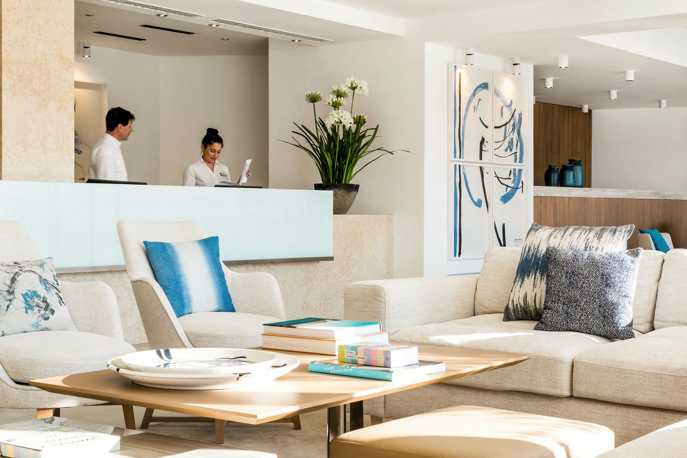 En lys og moderne hotellobby med sitteplasser, et resepsjonsområde og dekorative gjenstander. (AI-generert tekst)