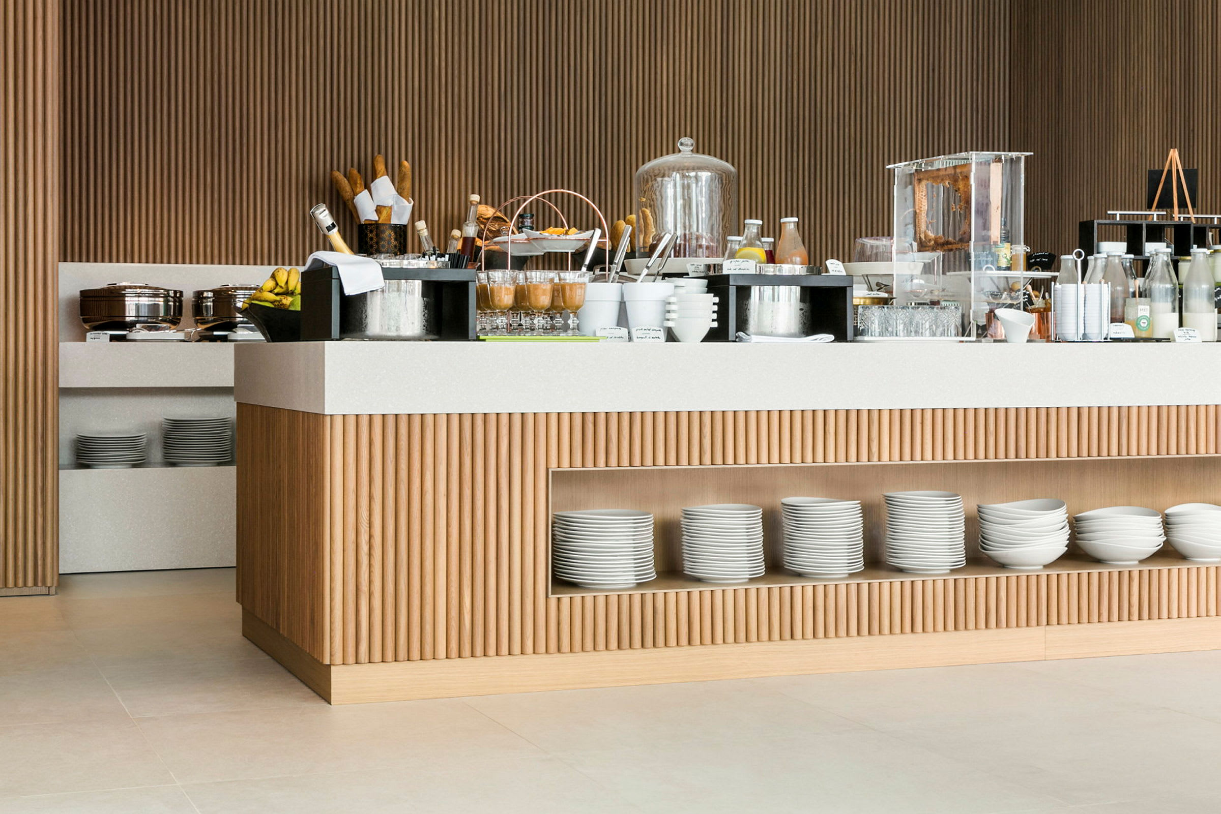 Frokostbuffet med ulike retter og drikker på et moderne serveringsbord av tre og lyse detaljer. (AI-generert tekst)