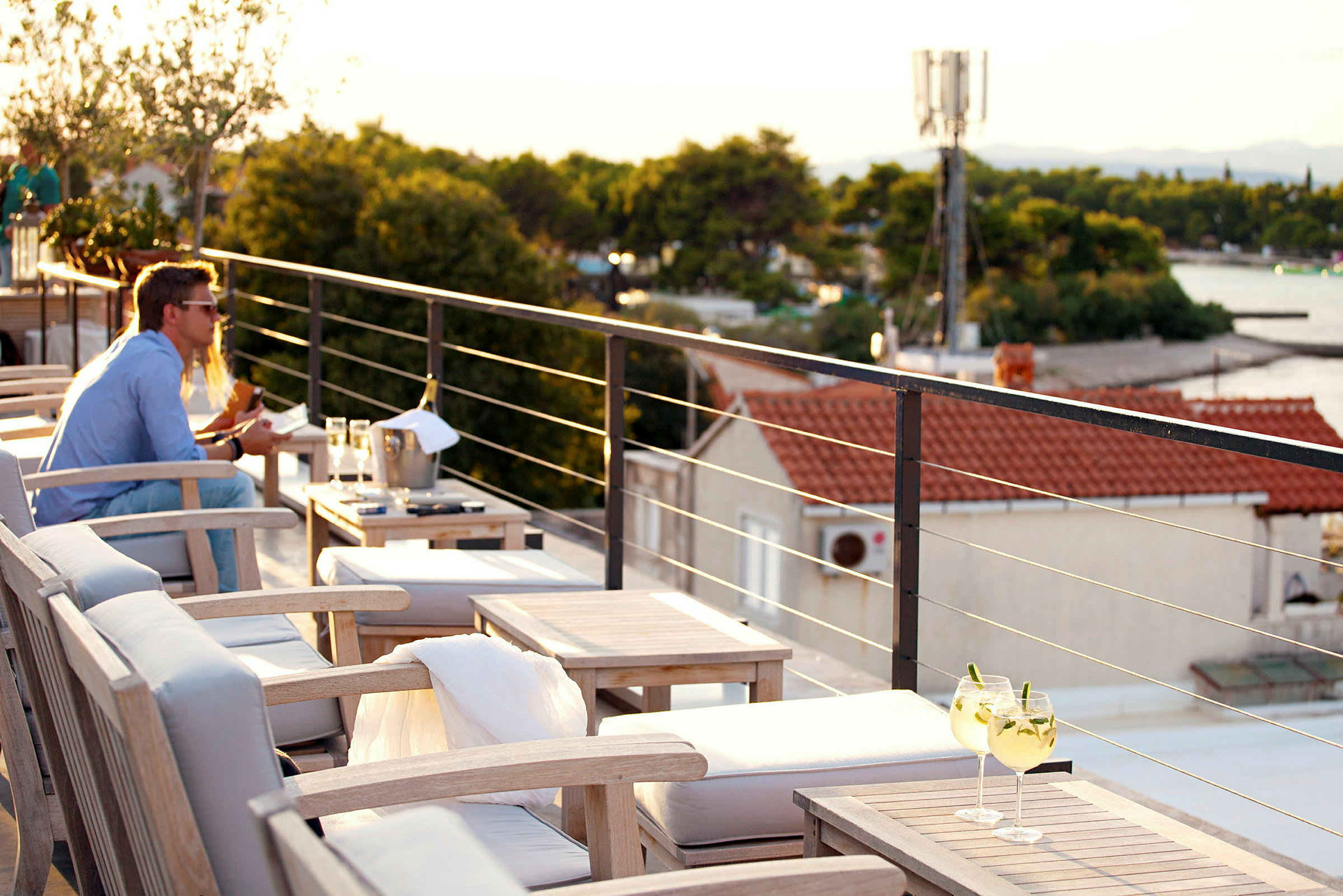 Terrasse med sitteplasser og utsikt over omgivelser med hus og natur. (AI-generert tekst)