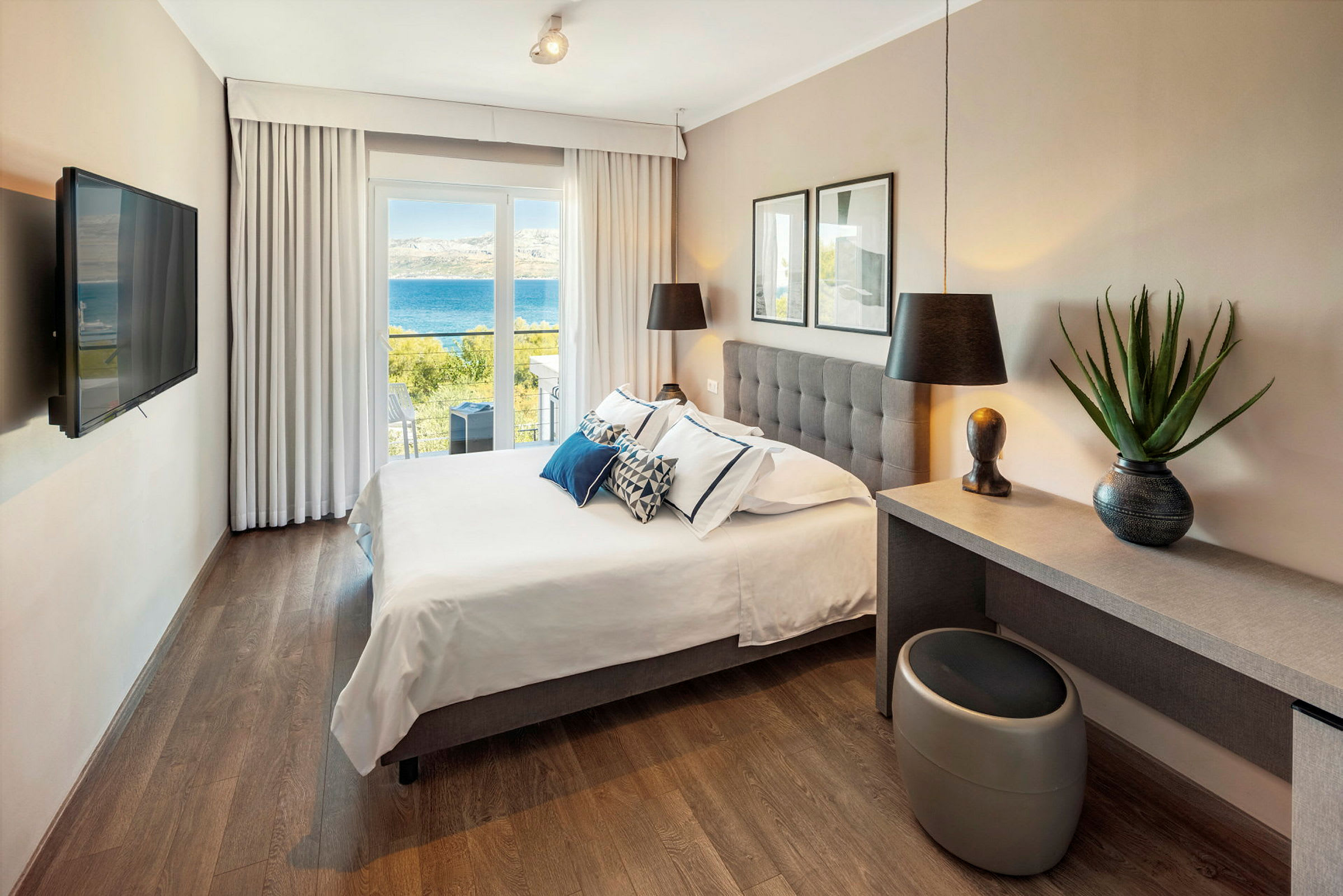 Hotellrom med dobbeltseng og utsikt over havet. (AI-generert tekst)
