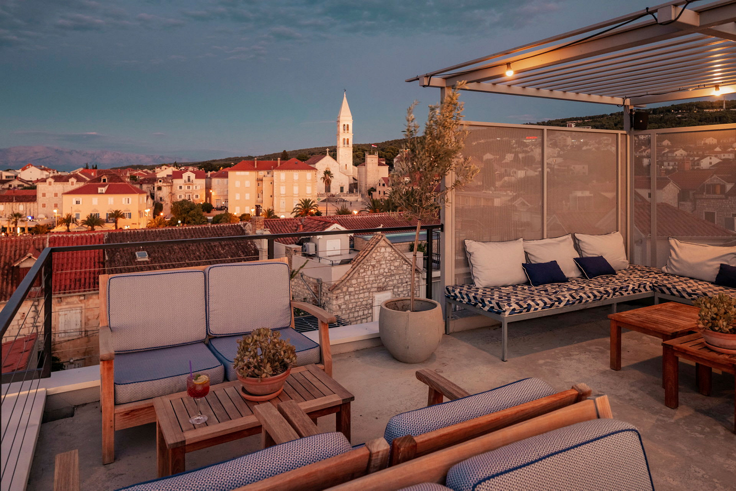 Takterrasse med utsikt over bygninger og kirke i en by. (AI-generert tekst)