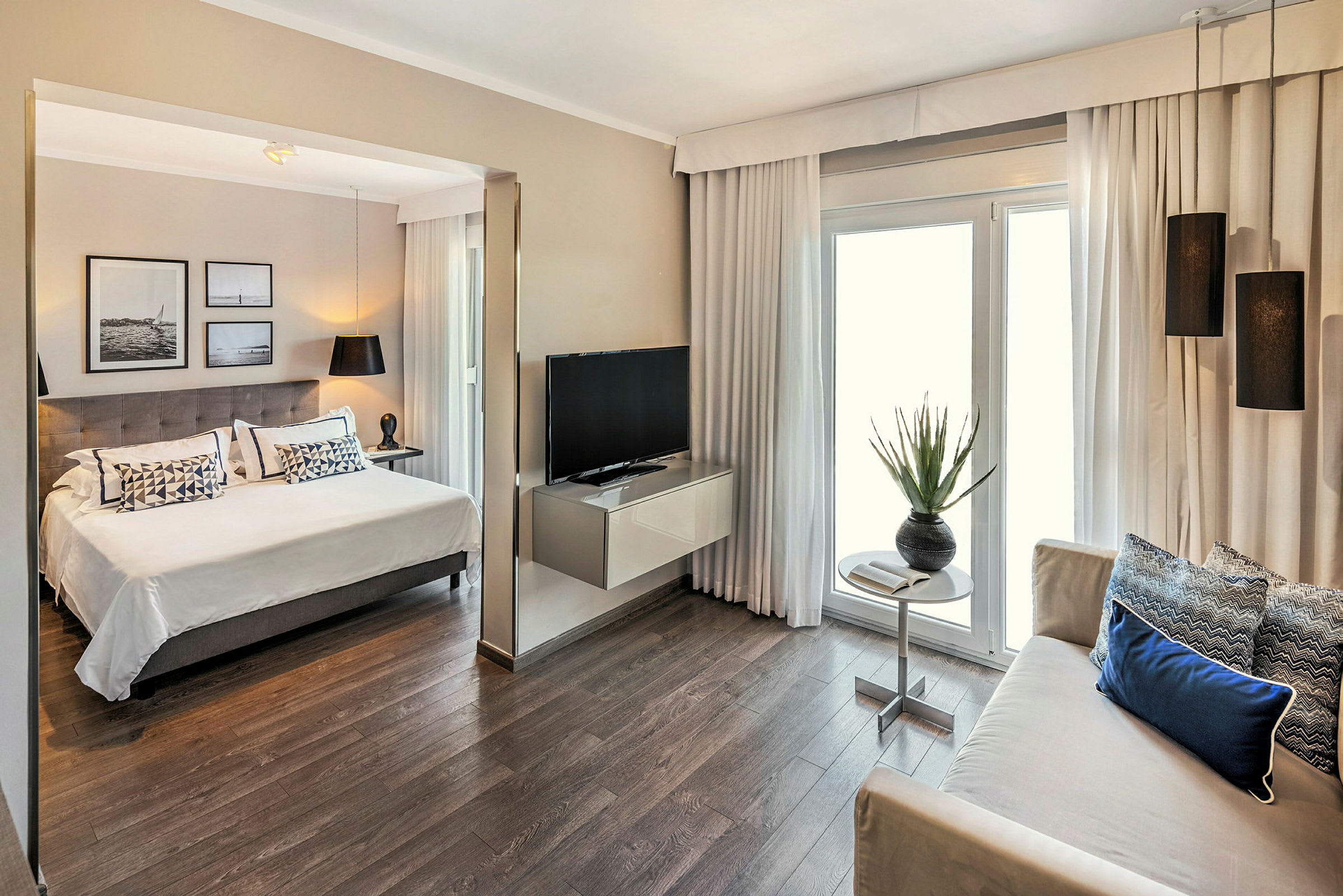 Bilde av et moderne hotellrom med en dobbeltseng, sittegruppe, TV og interiørdetaljer. (AI-generert tekst)