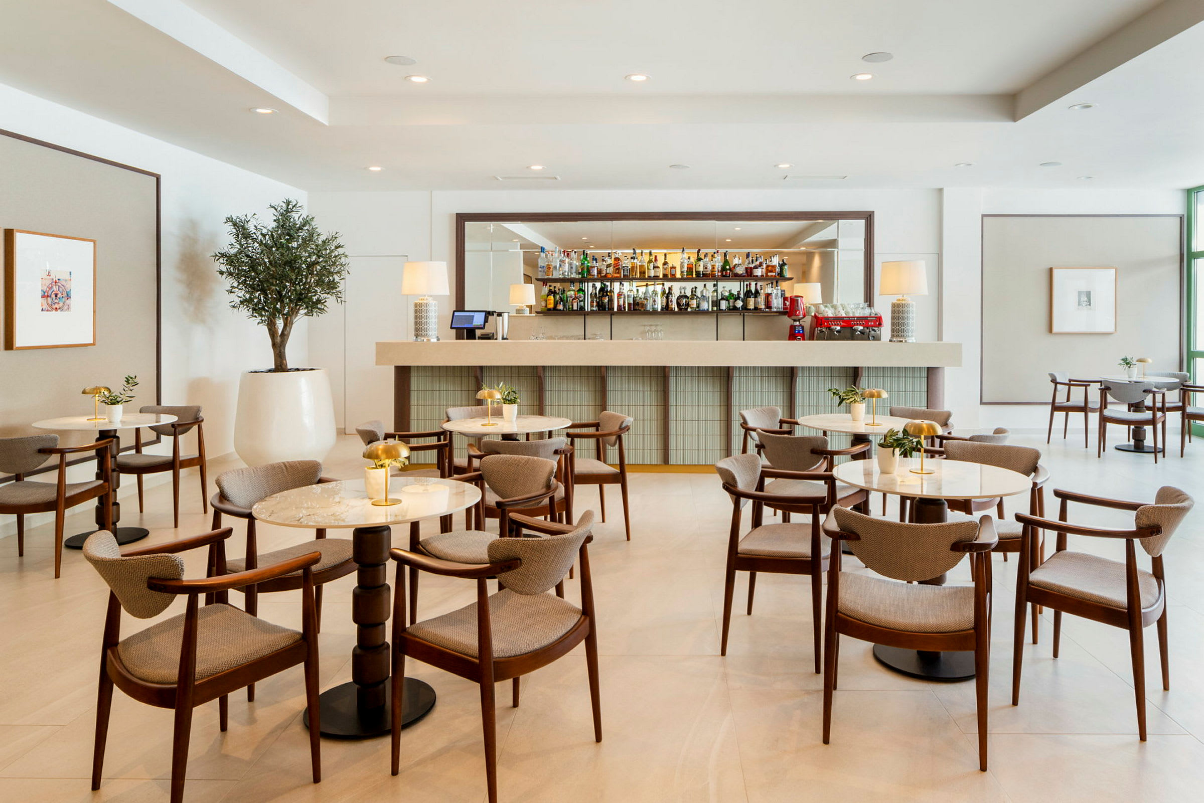 Moderne bar med elegante bord og stoler i et lyst interiør. (AI-generert tekst)