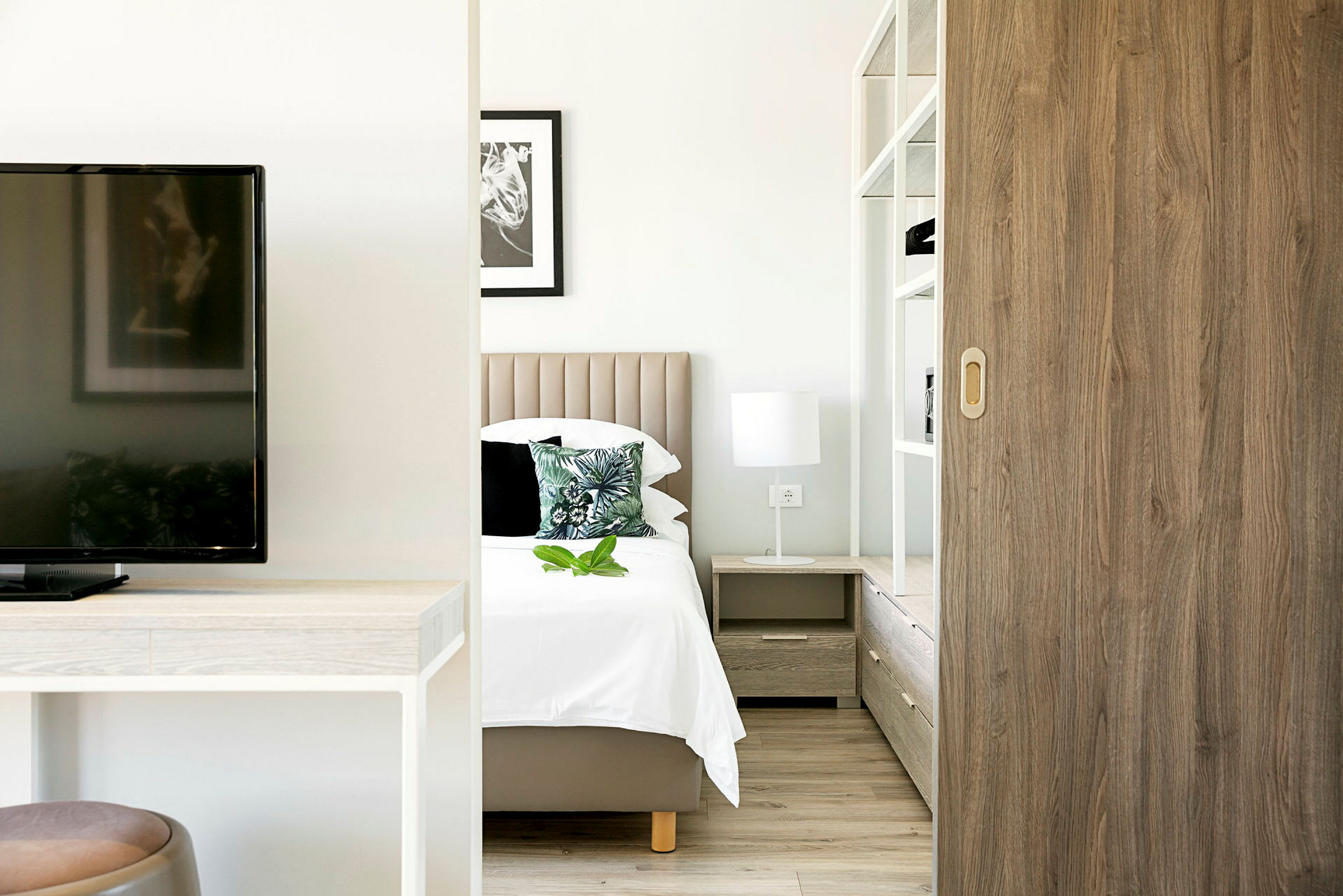 Et moderne hotellrom med seng, nattbord og interiør. (AI-generert tekst)