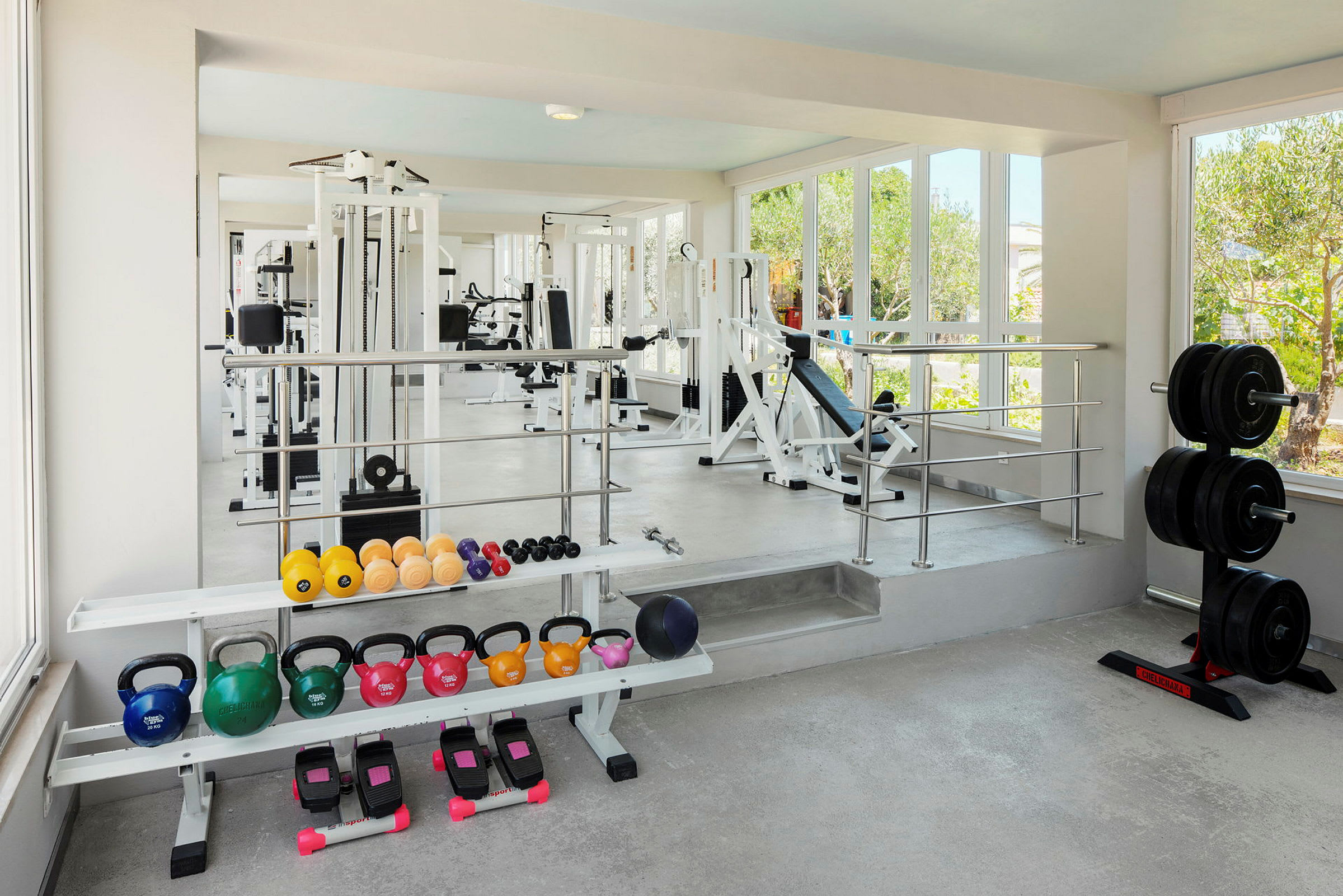 Et treningsstudio med ulike treningsapparater, frivekter og kettlebells. (AI-generert tekst)