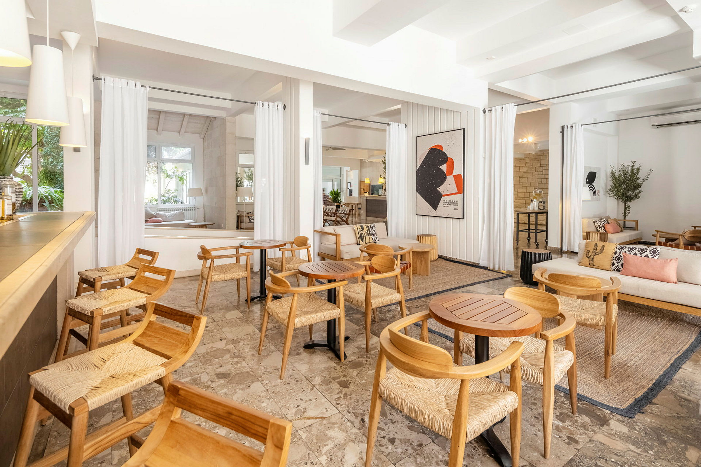 Lounge med trestoler og bord, lyst og moderne innredet. (AI-generert tekst)