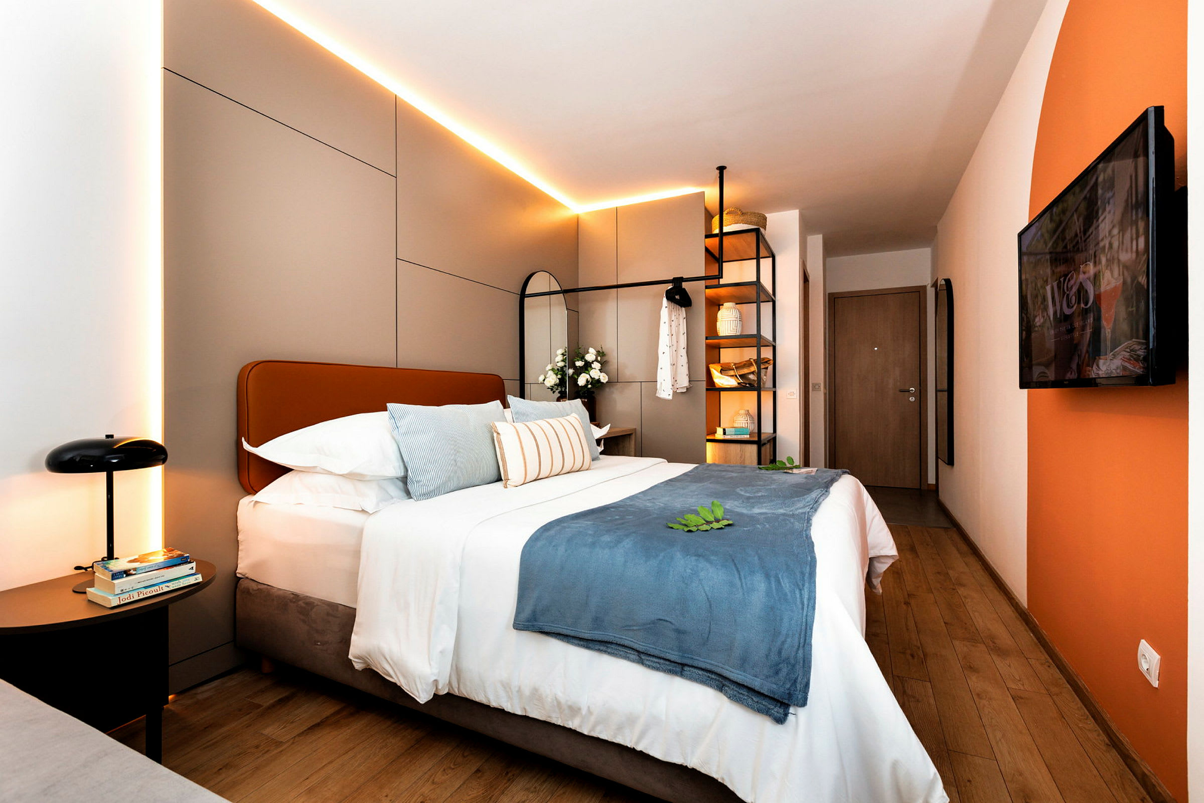Moderne hotellrom med dobbeltseng, dekorative puter og belysning. (AI-generert tekst)