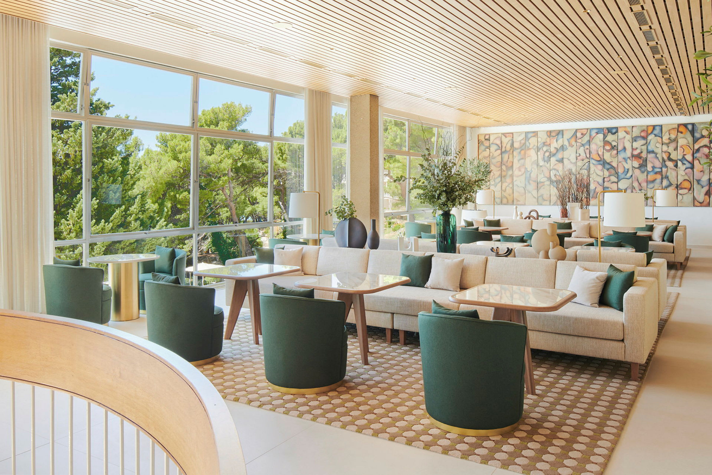 En lys og moderne lounge med grønne møbler, store vinduer og veggkunst. (AI-generert tekst)