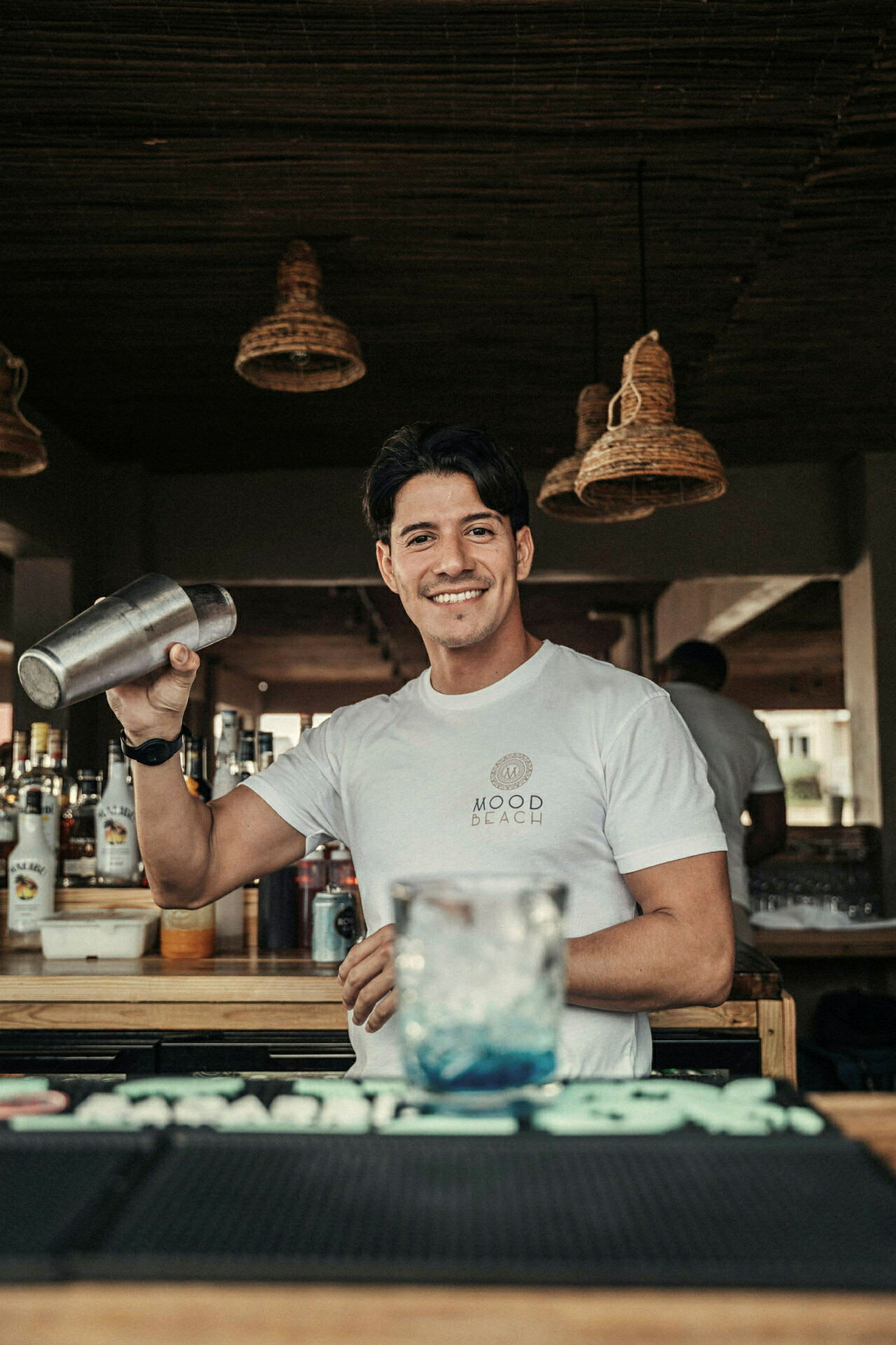 En bartender holder en cocktailshaker bak en bardisk. (AI-generert tekst)