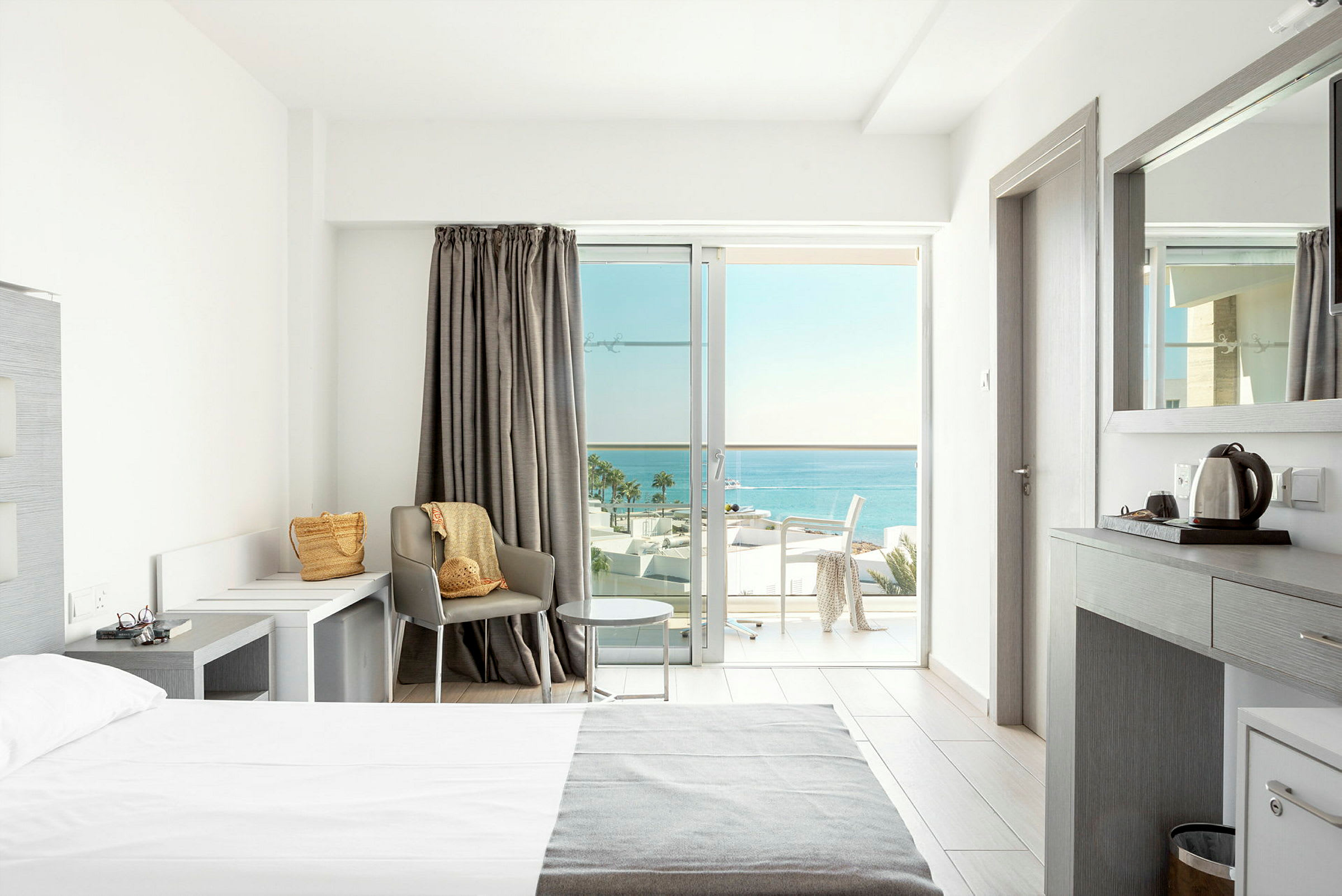 Lyst hotellrom med moderne innredning og havutsikt. (AI-generert tekst)
