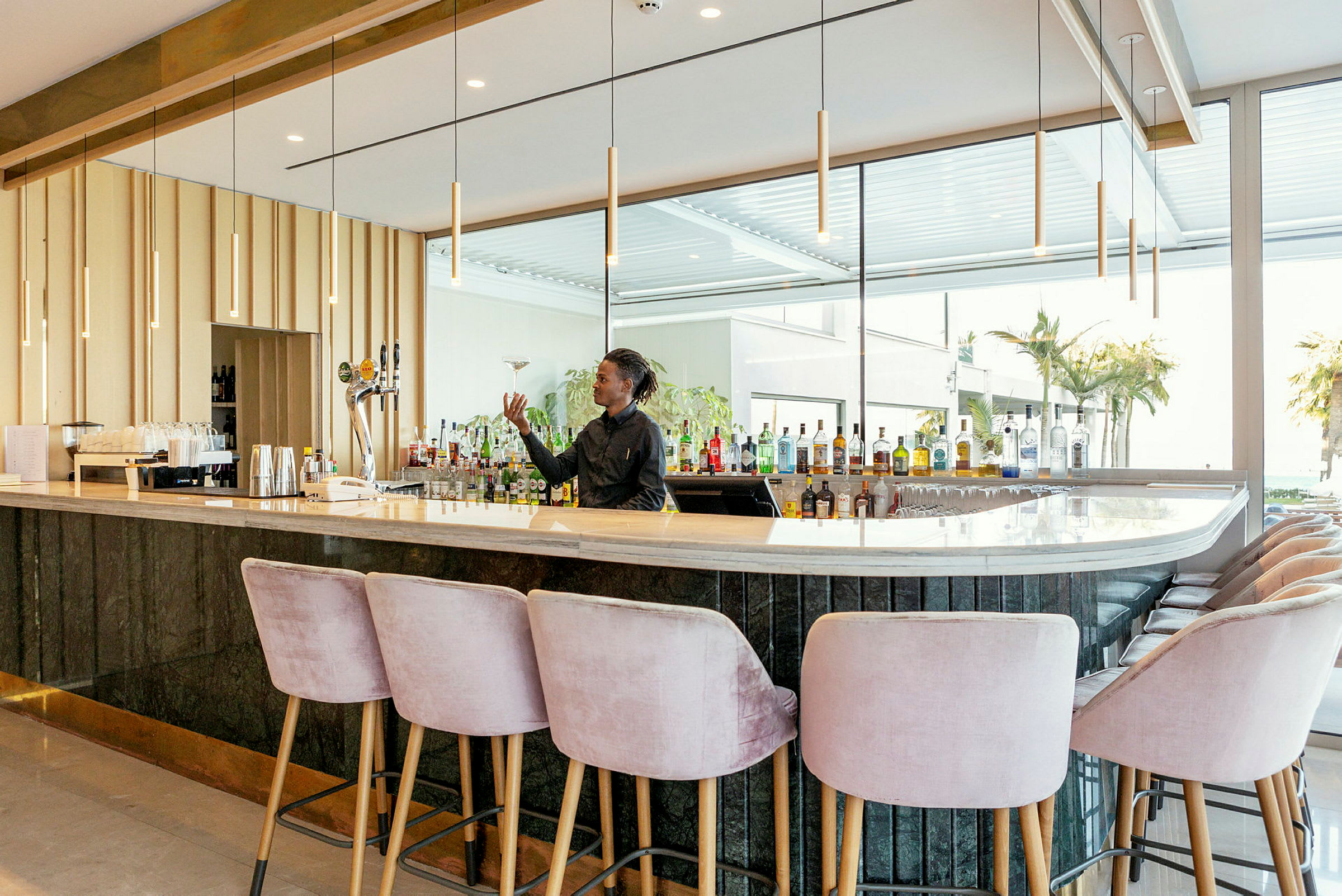 En elegant bar med lyse stoler og en velutstyrt bak bardisk. (AI-generert tekst)