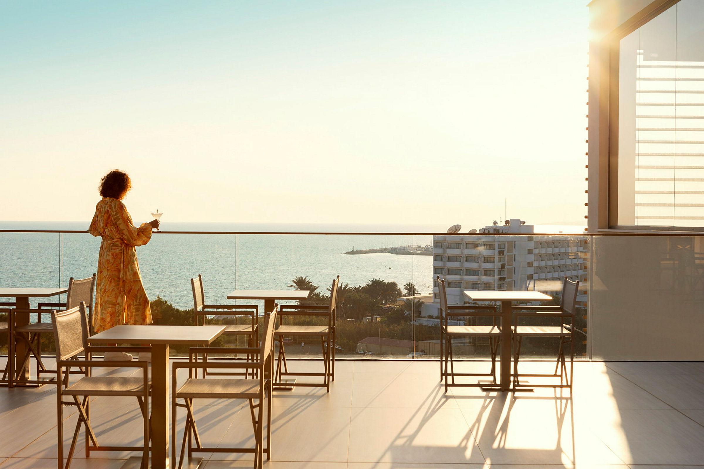 Person på en terrasse med utsikt over havet. (AI-generert tekst)