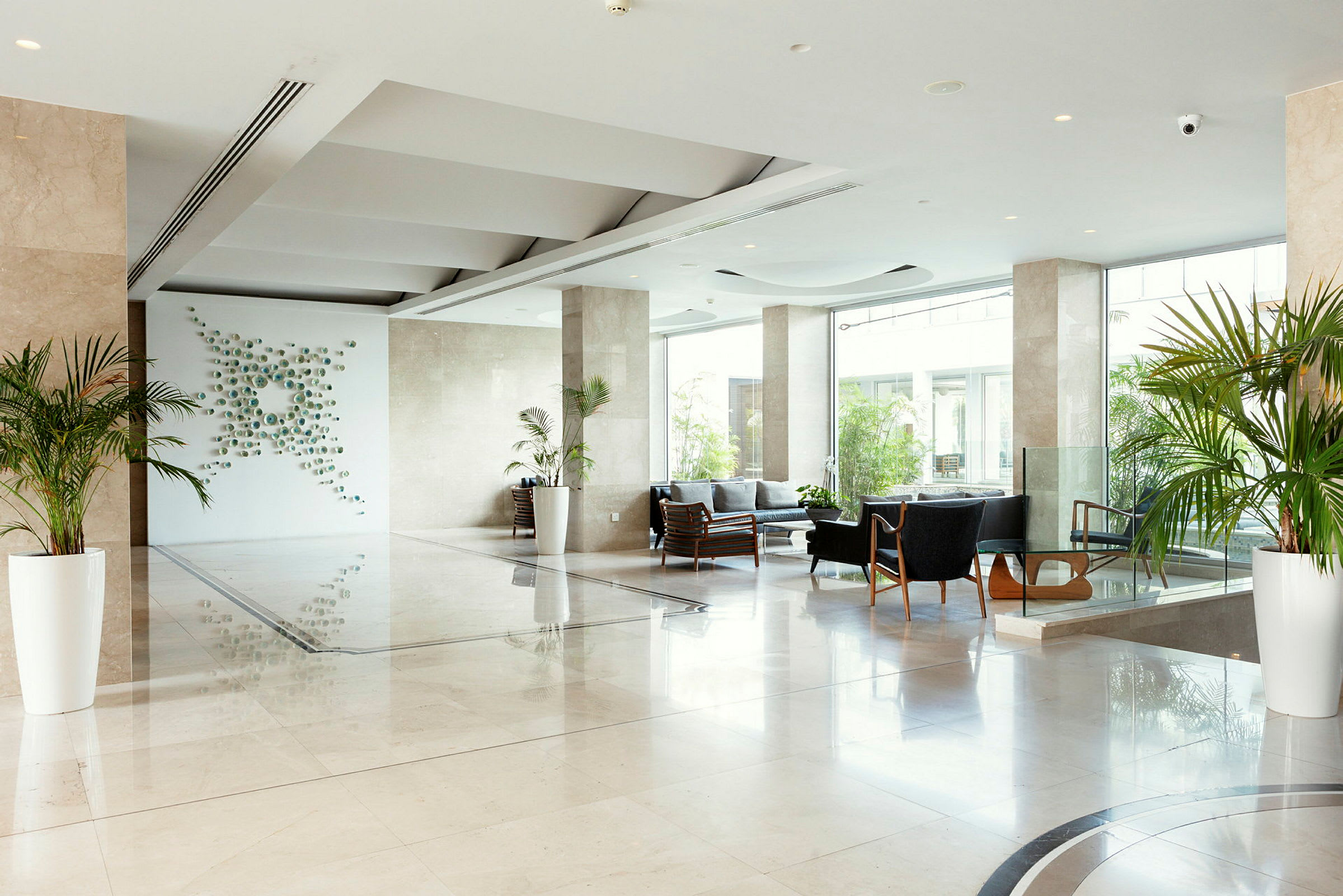 Moderne hotellobby med sittegrupper og planter. (AI-generert tekst)