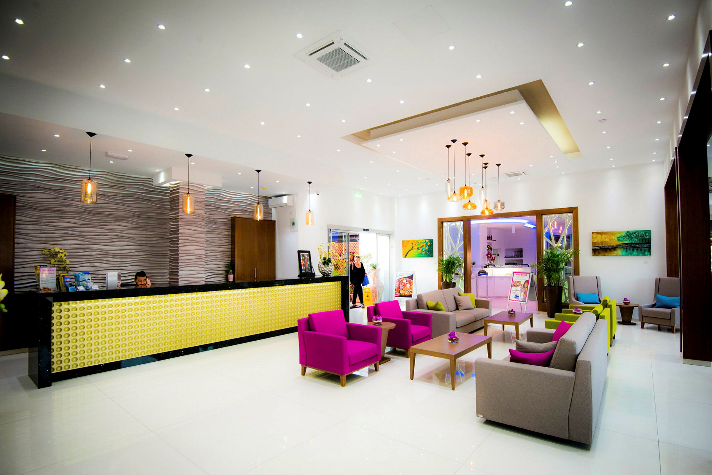 Resepsjon i en moderne hotellobby med fargerike møbler og elegant interiør. (AI-generert tekst)