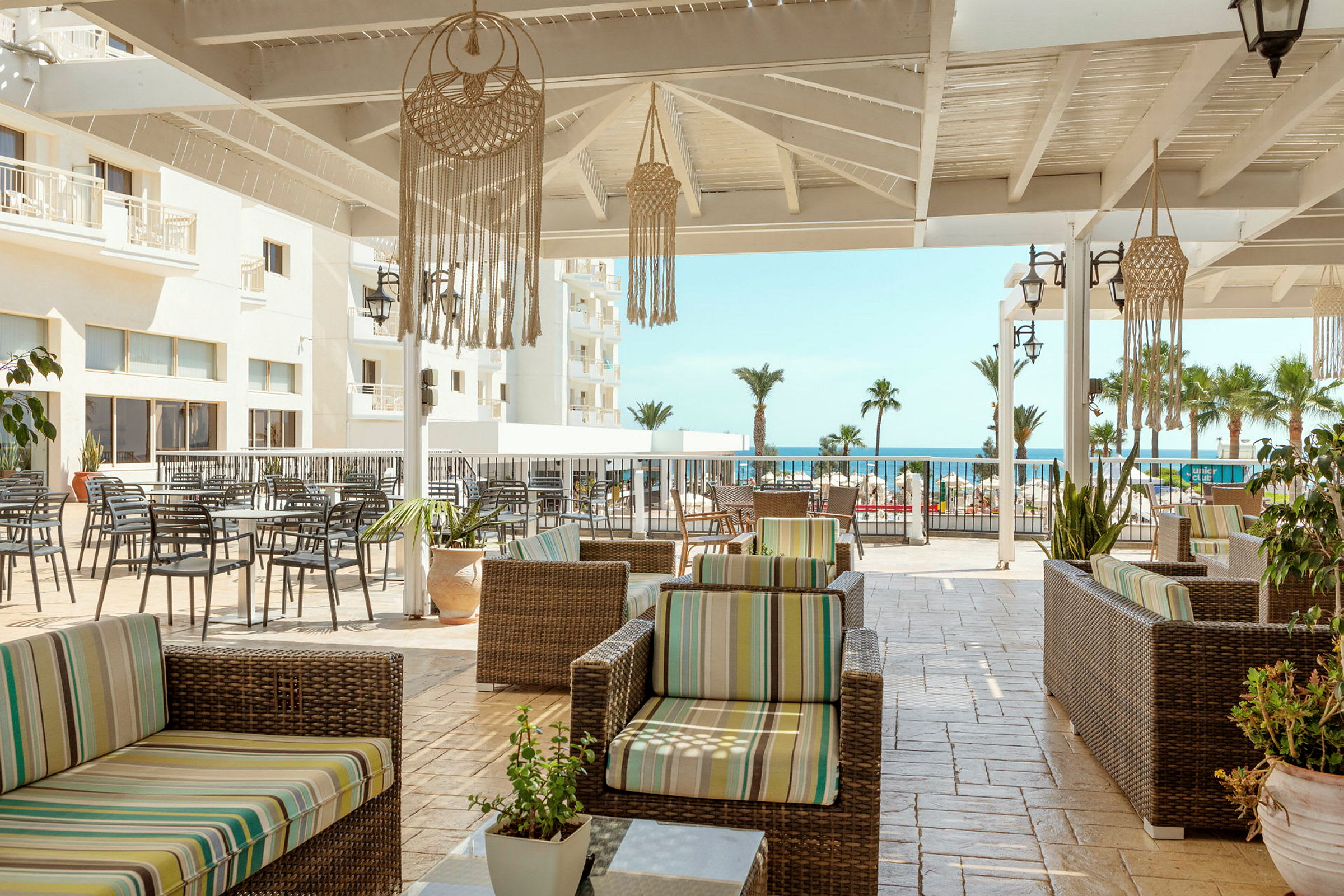Terrasse med sittemøbler og utsikt mot havet. (AI-generert tekst)