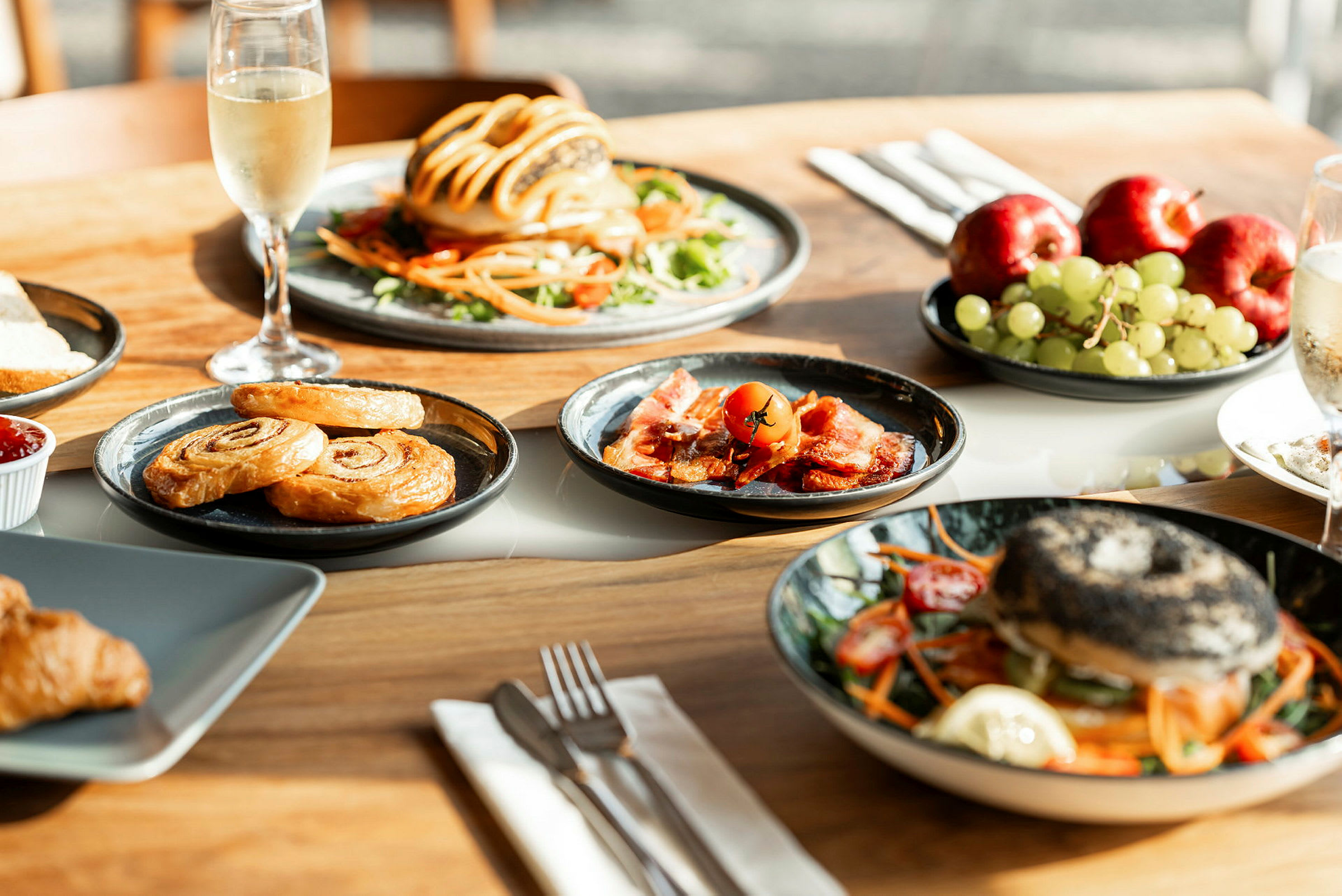 Et bord med ulike retter, inkludert bakverk, frukt og salat. (AI-generert tekst)