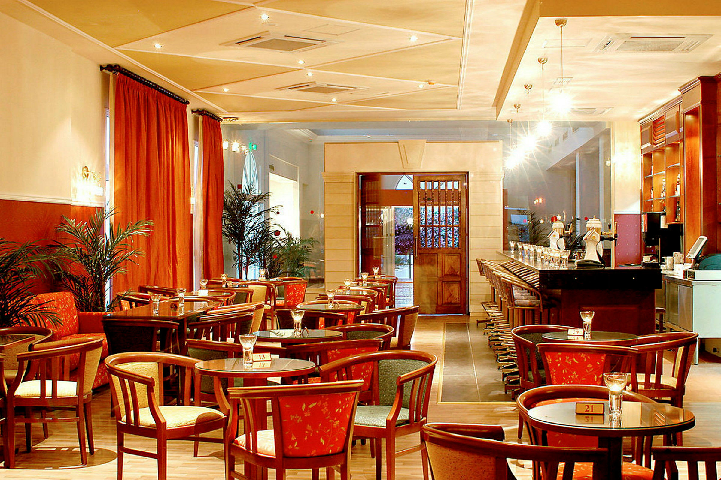 Interiør av en restaurant med bord, stoler og bar. (AI-generert tekst)