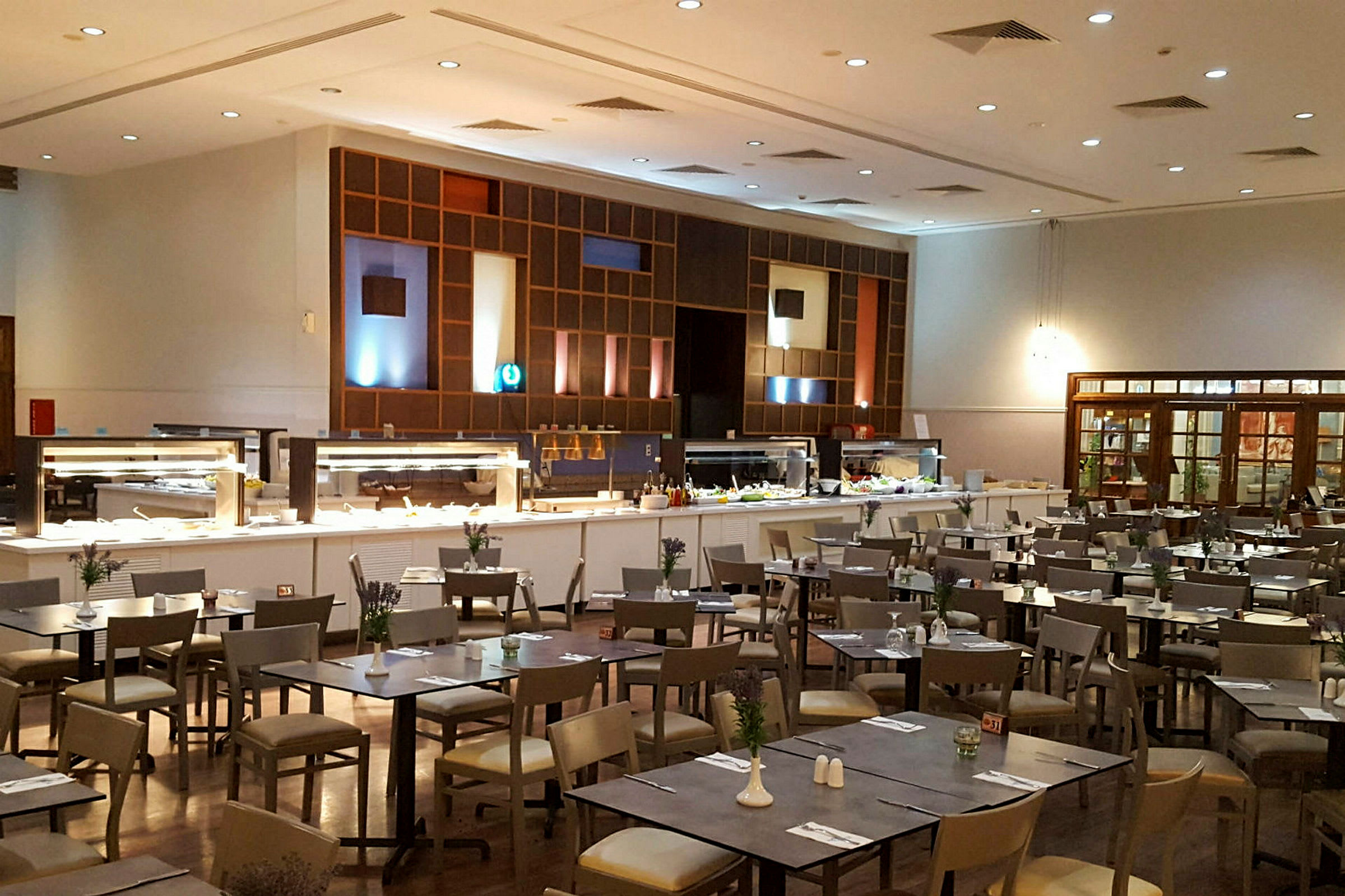 En restaurant med buffetområde og spisebord. (AI-generert tekst)