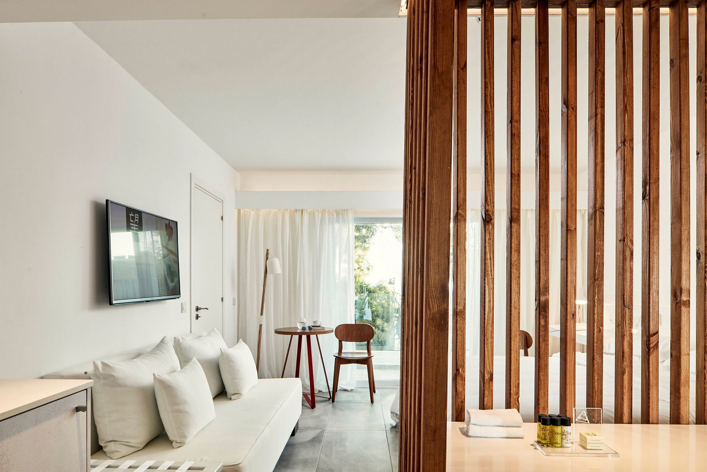 Bilde av et moderne hotellrom med lys innredning, tredetaljer og en sofa. (AI-generert tekst)