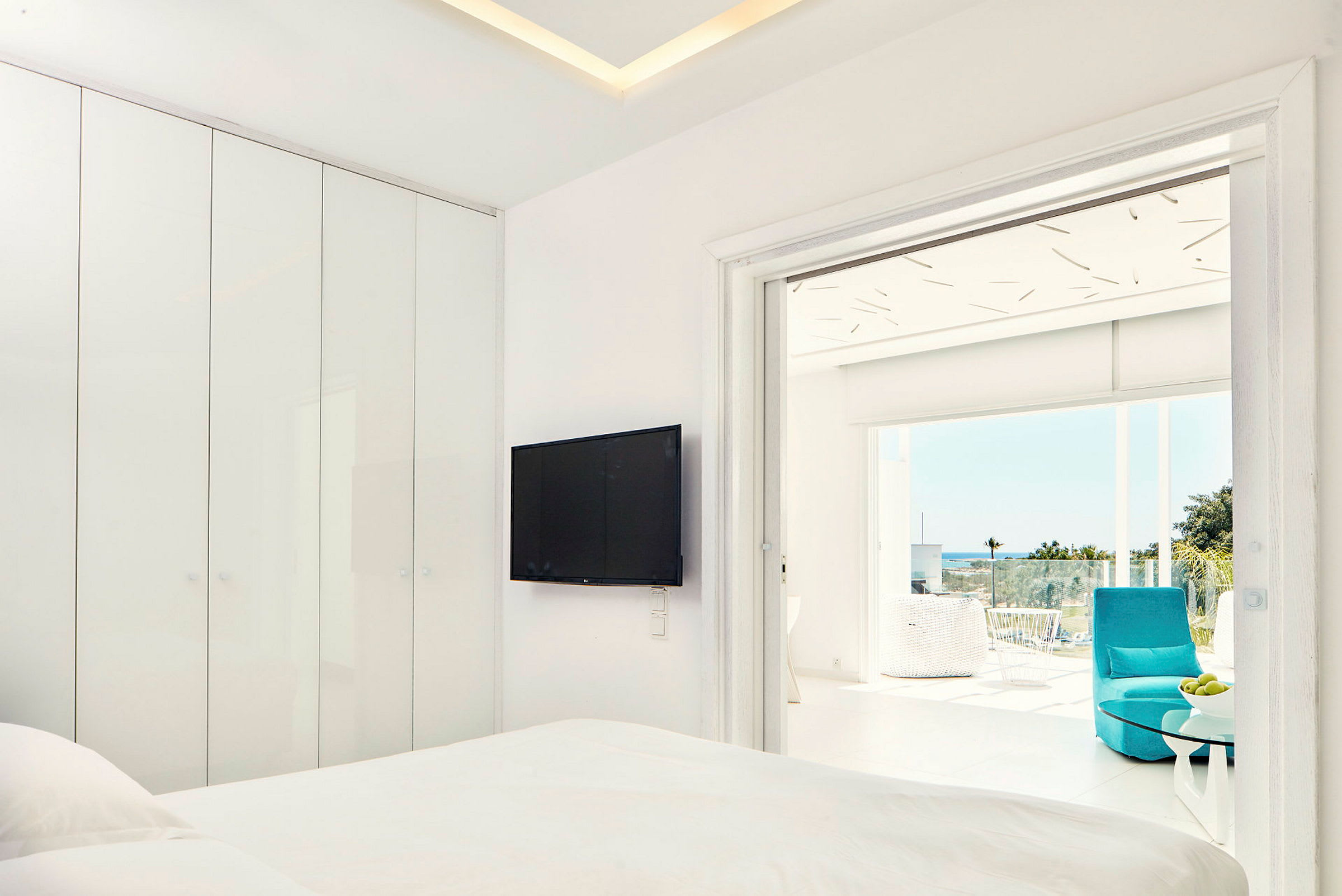 Moderne hotellrom med flatskjerm-TV og tilknyttet balkong med utsikt. (AI-generert tekst)