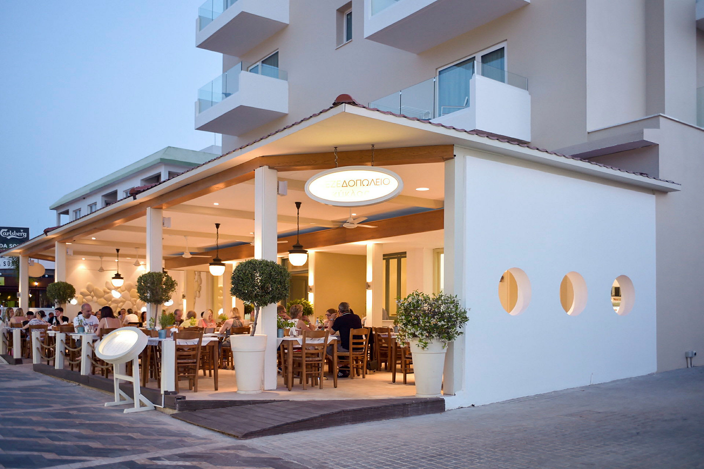 Utendørs terrasse med sitteplasser på en restaurant ved siden av en bygning. (AI-generert tekst)