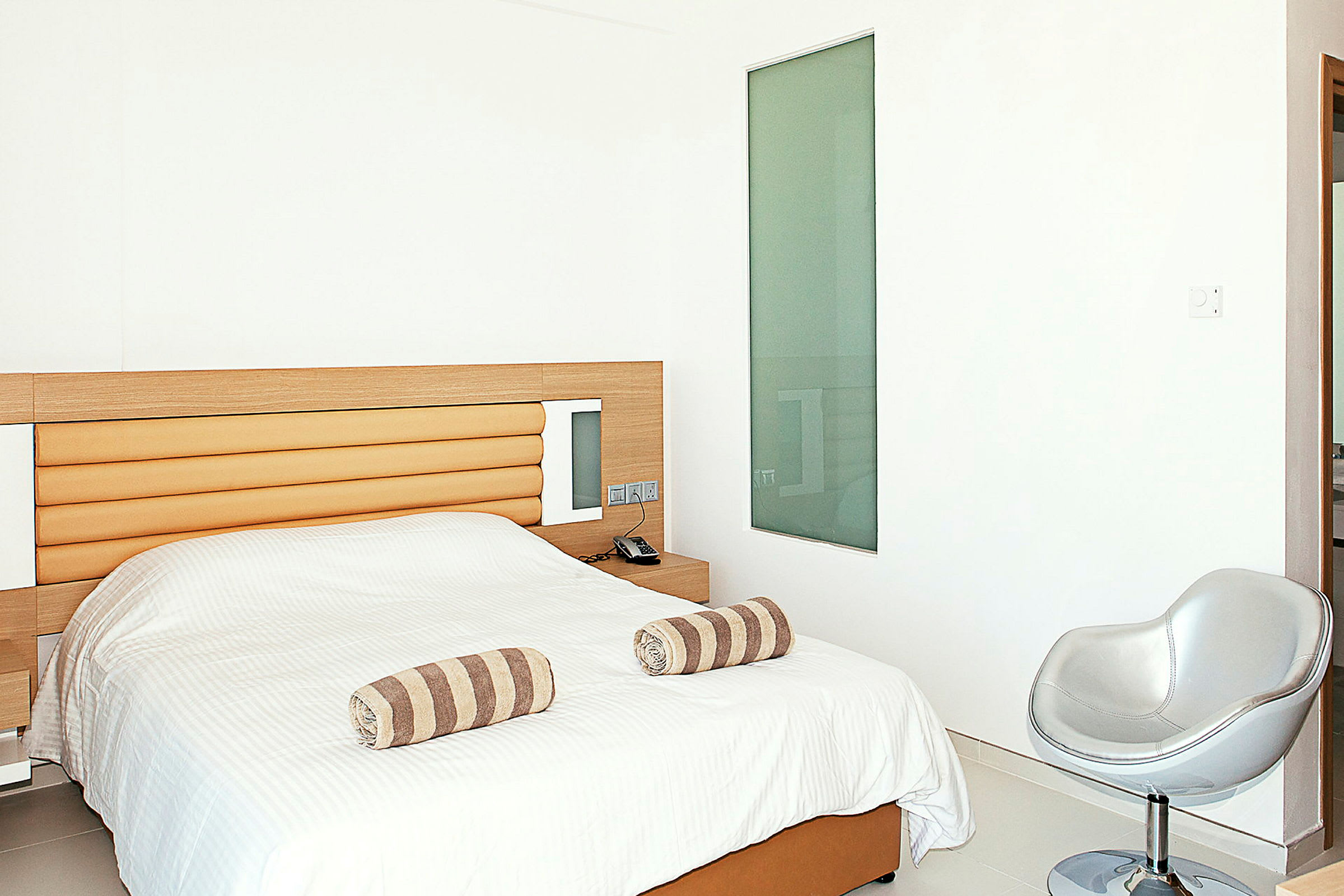 Hotellrom med en seng og minimalistisk innredning. (AI-generert tekst)