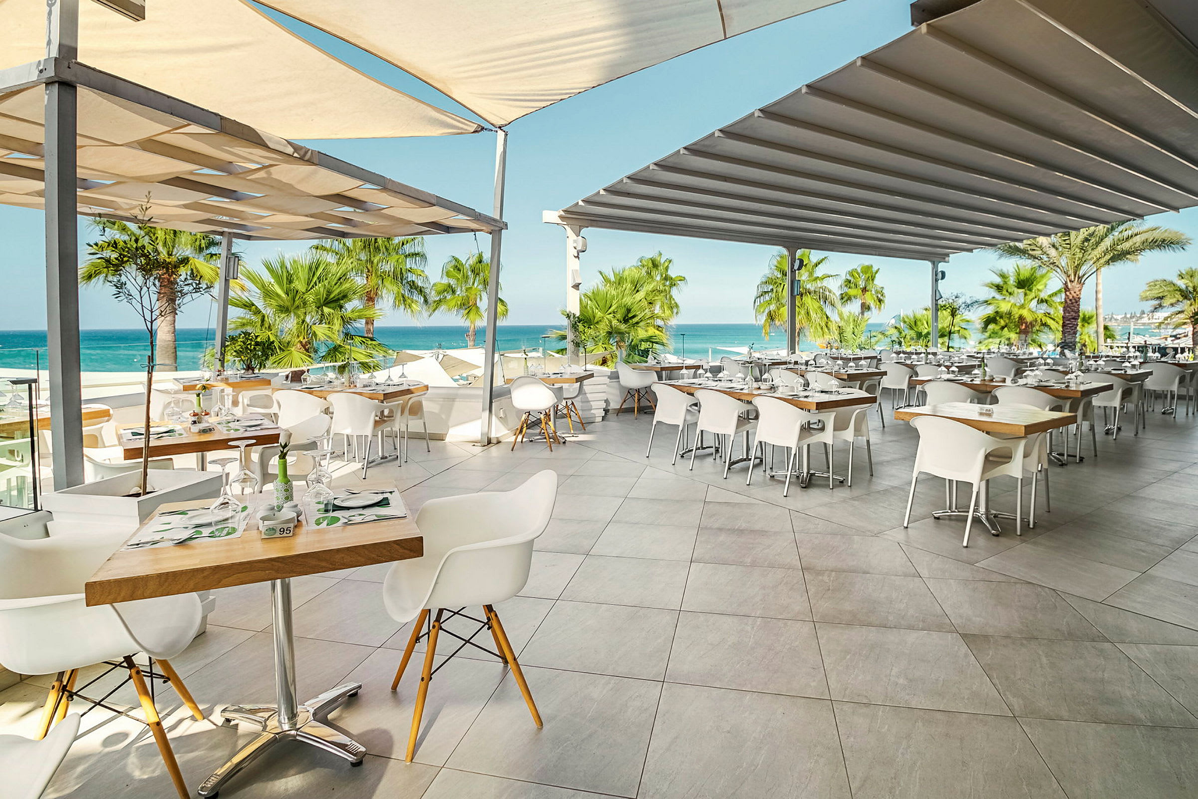 Restaurant med uteservering, utsikt mot havet. (AI-generert tekst)