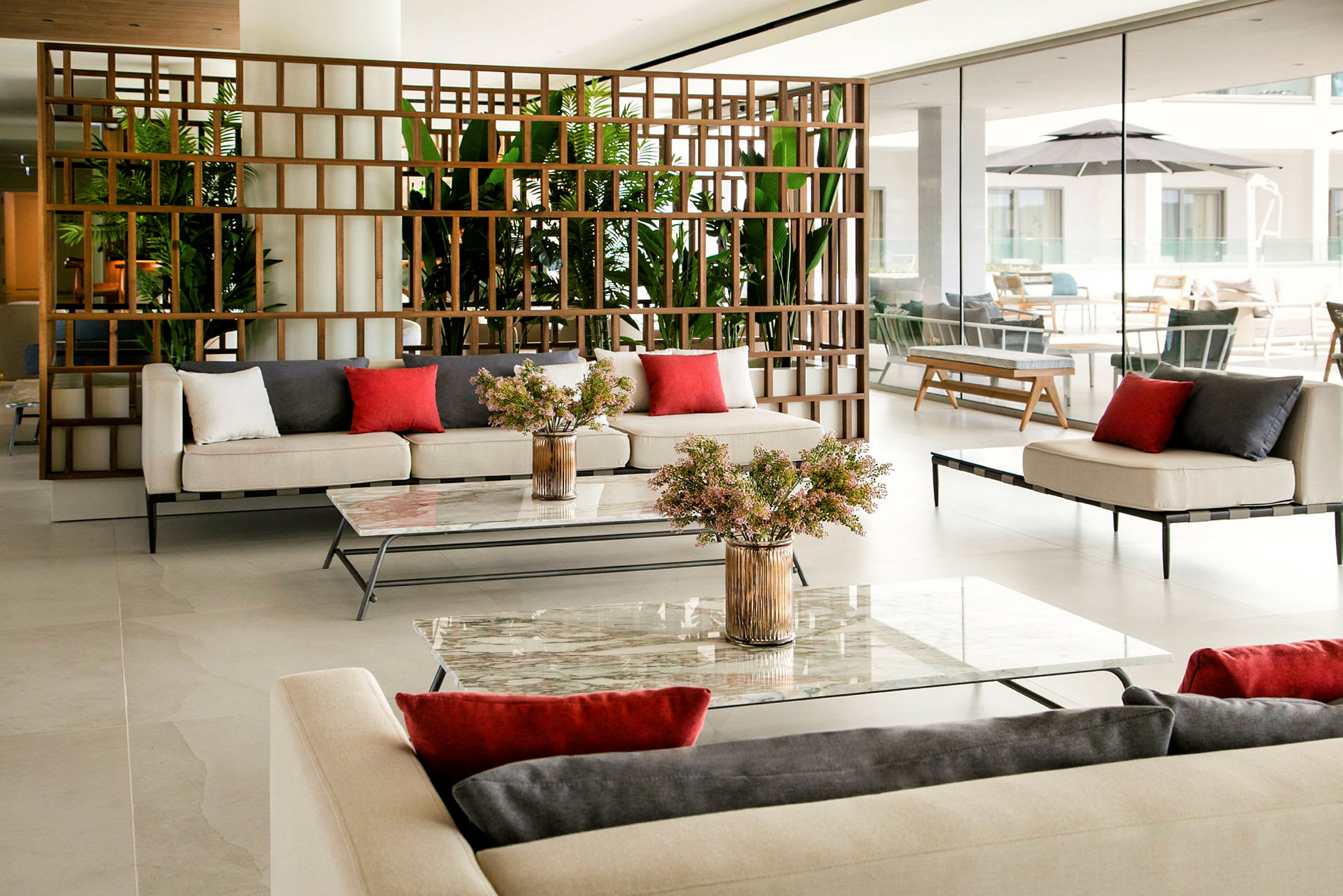En moderne lounge med sofaer, bord og grønne planter. (AI-generert tekst)