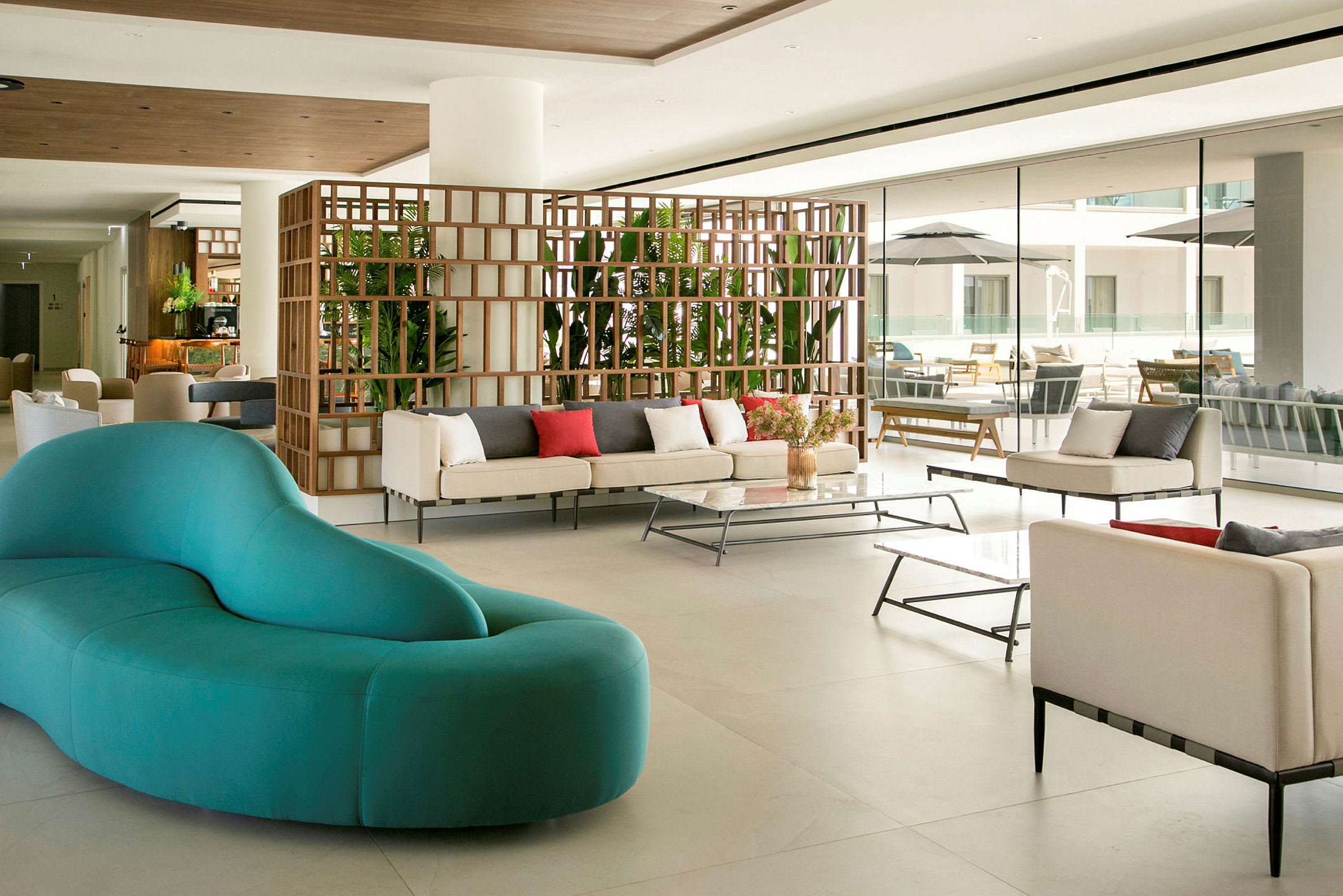 En moderne hotellobby med sofaer, bord og planter. (AI-generert tekst)