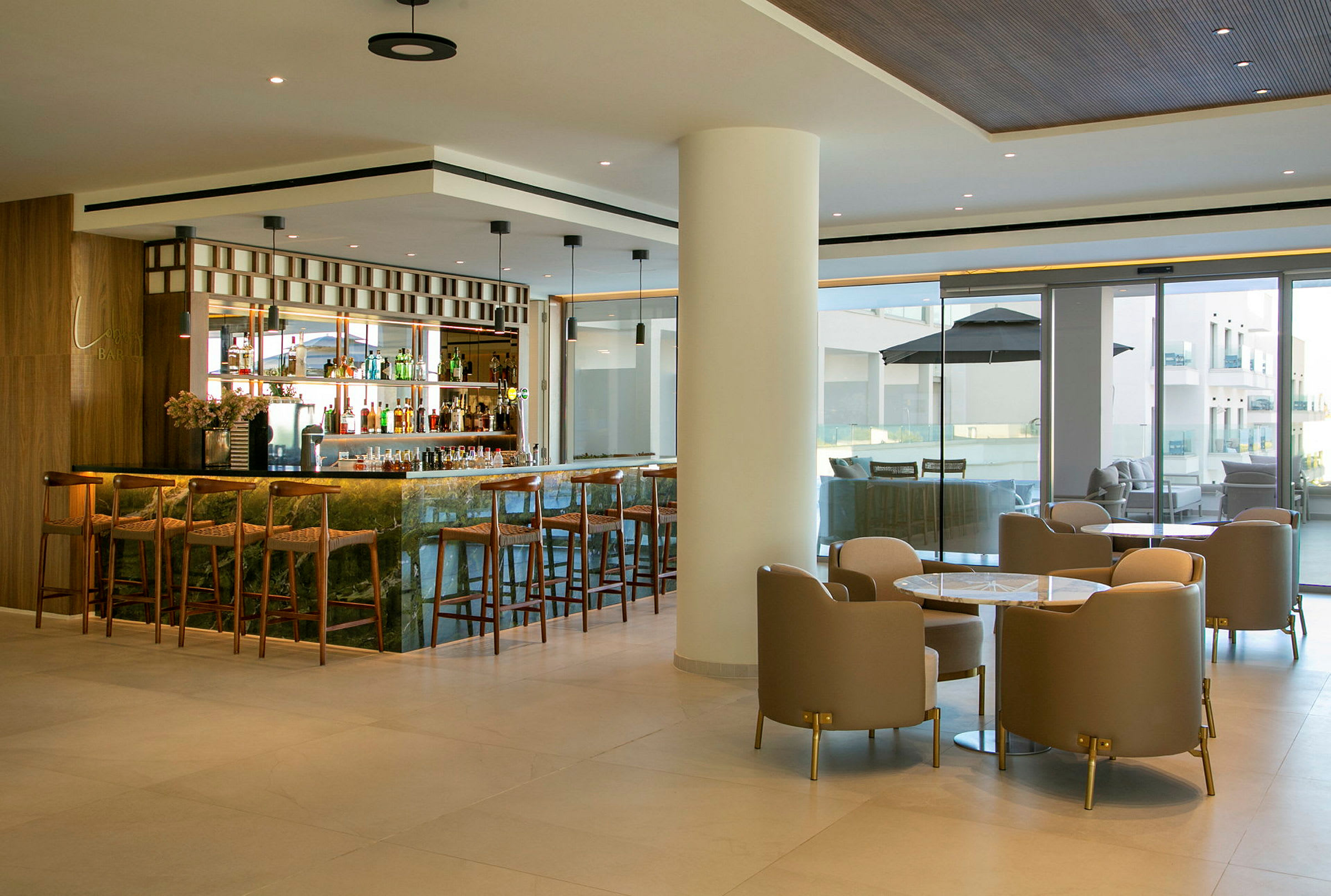 Bilde av en moderne hotellbar med barkrakker og sittegrupper. (AI-generert tekst)