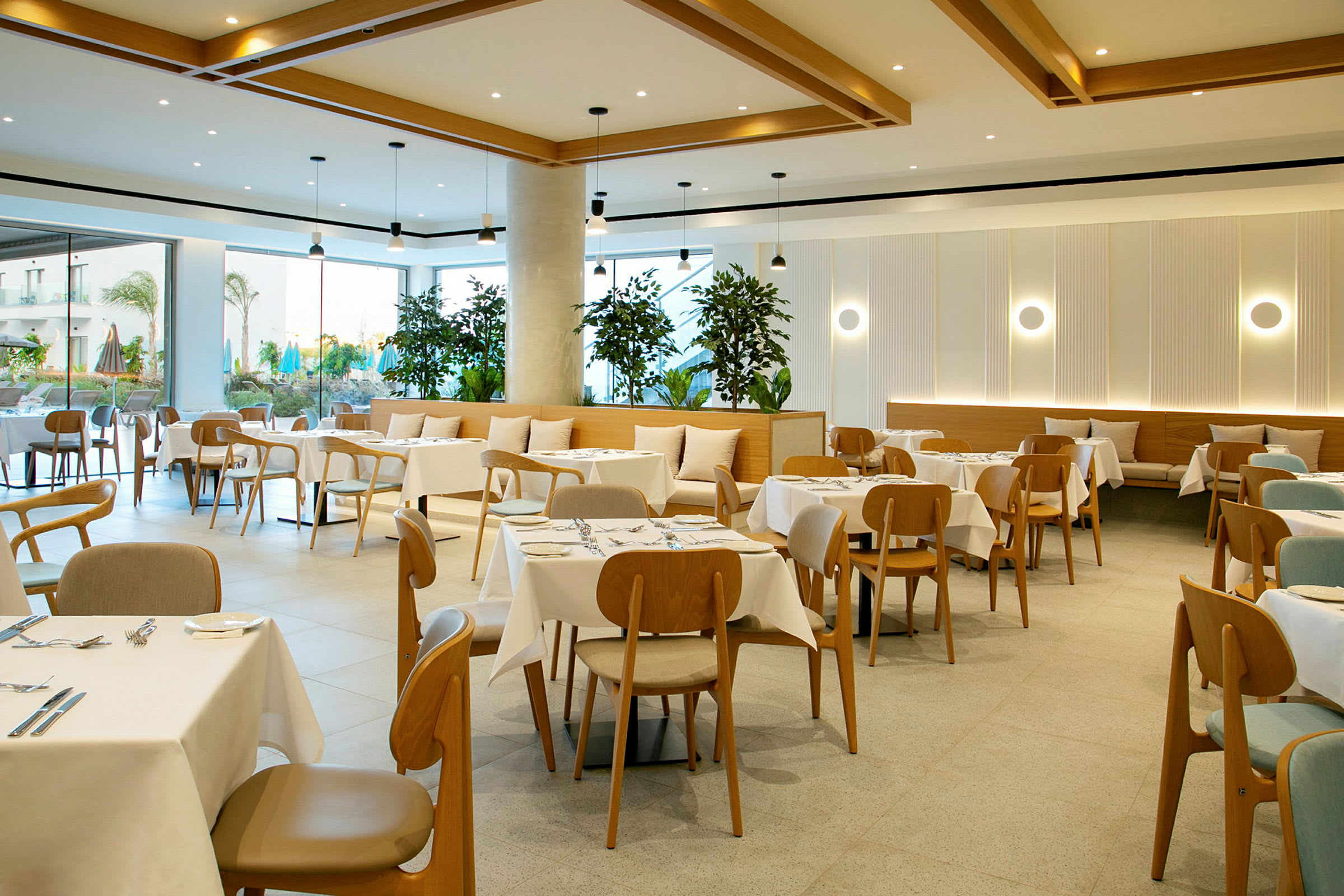 En moderne restaurant med oppdekkede bord og trestoler samt dekorative planter. (AI-generert tekst)