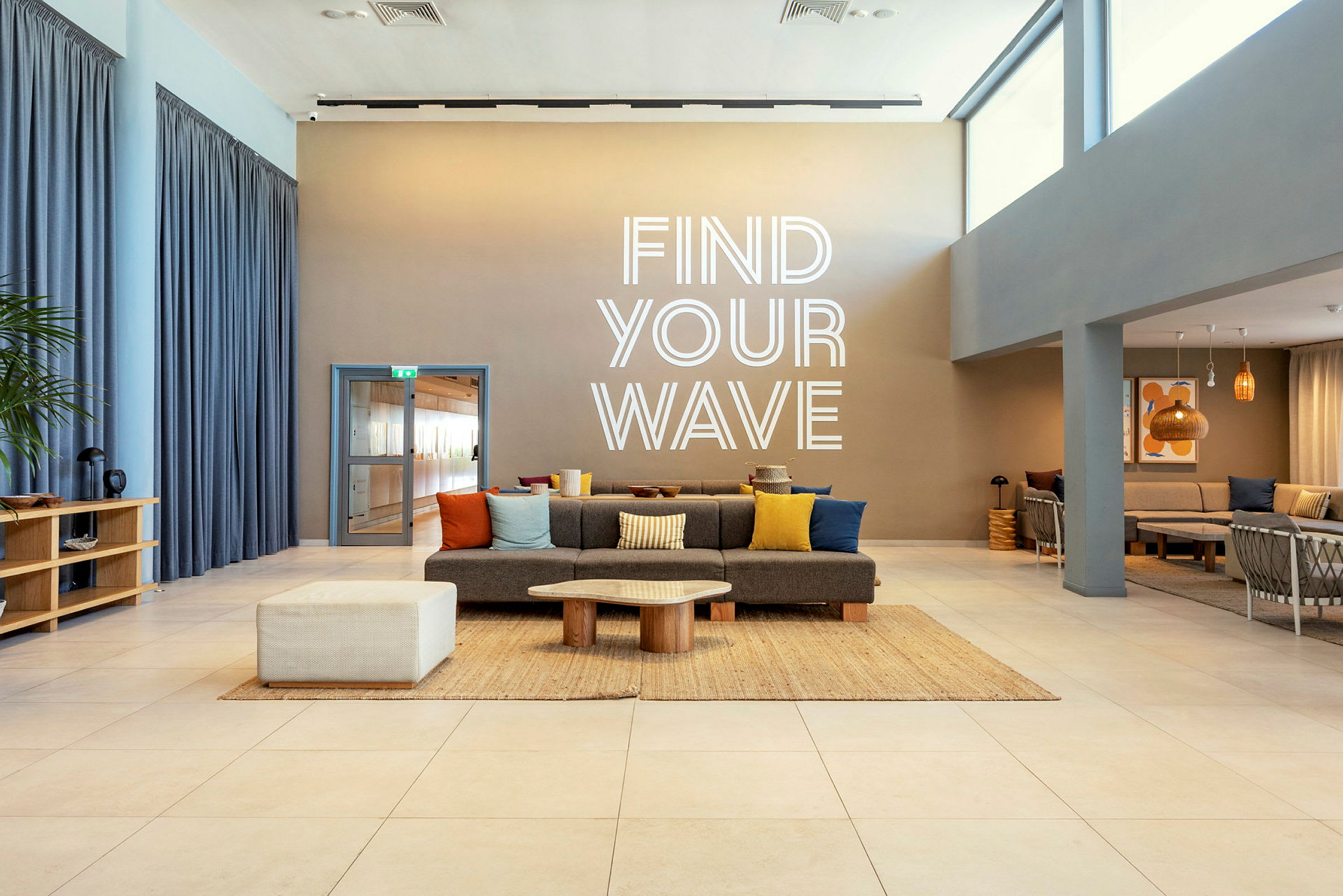 Et moderne rom med sitteplasser og tekst på veggen som sier 'Find Your Wave'. (AI-generert tekst)