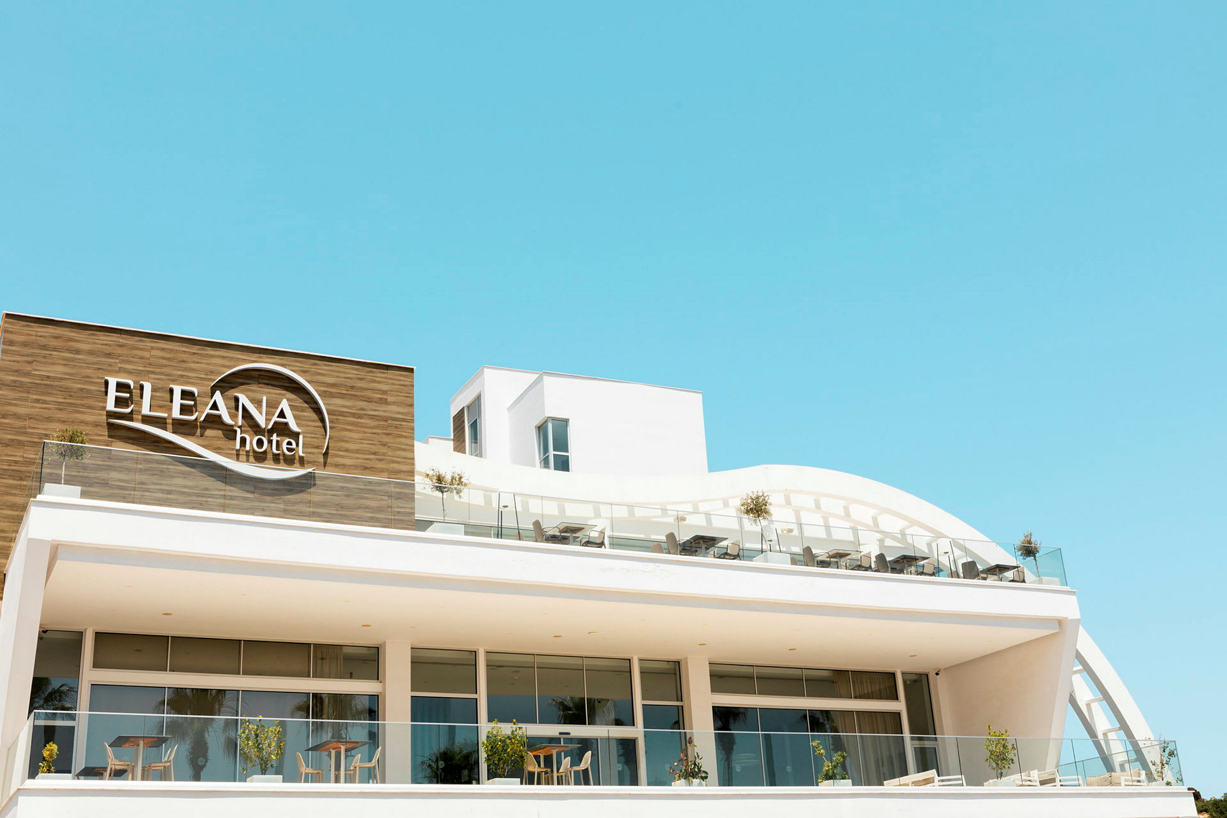Moderne hotell med navnet Eleana Hotel synlig på fasaden. (AI-generert tekst)