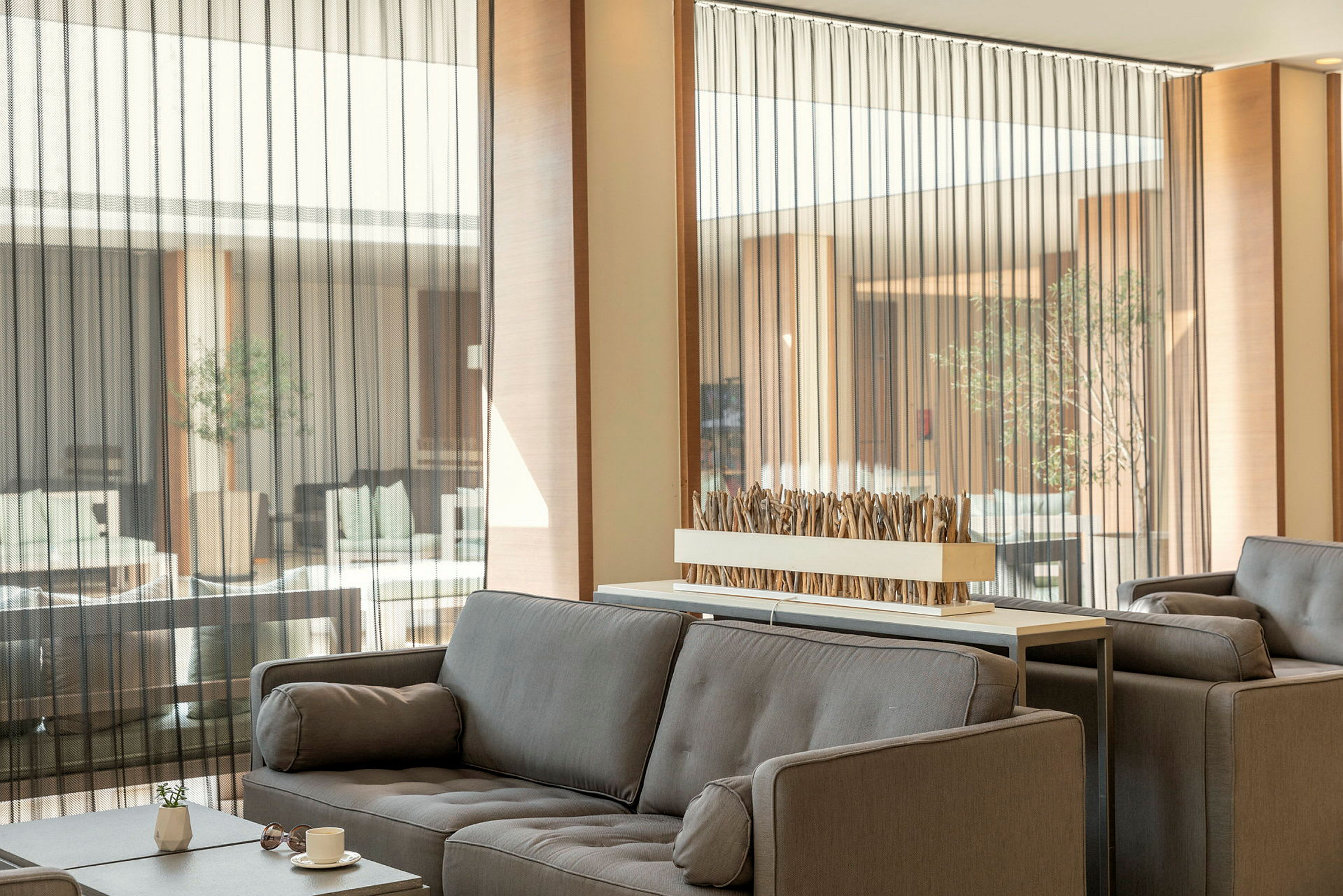 Moderne lounge med grå sofaer og dekorativ borddekorasjon. (AI-generert tekst)
