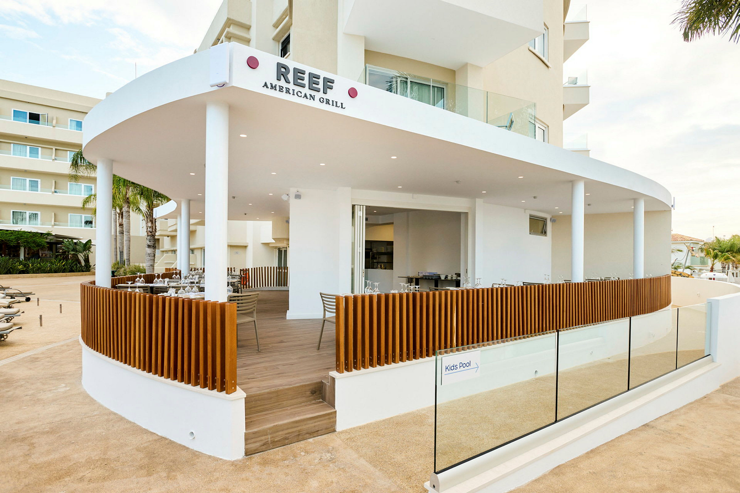 Bilde av en restaurant, Reef American Grill, med en åpen terrasse og moderne design. (AI-generert tekst)