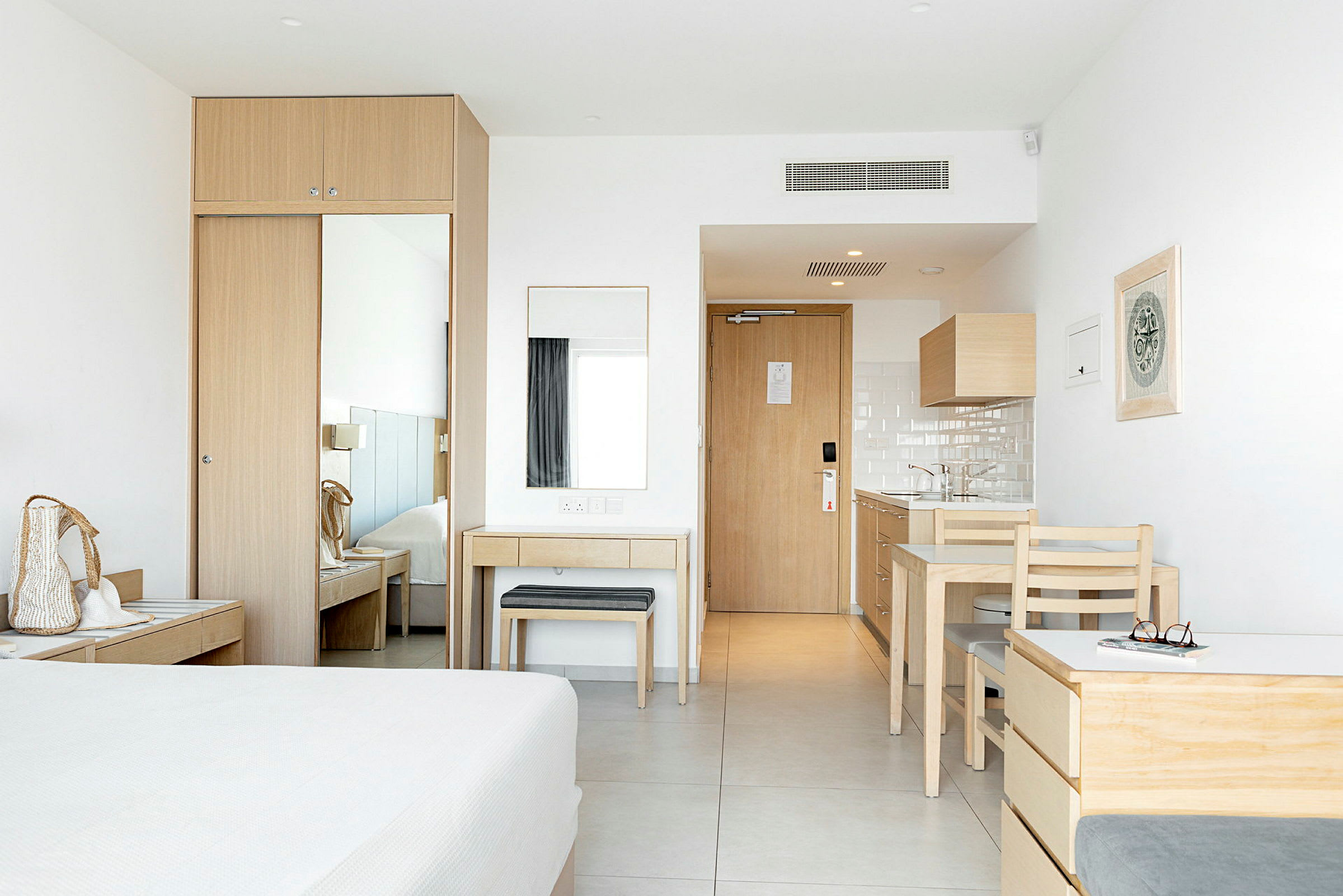 Et hotellrom med lys innredning og møbler i tre. (AI-generert tekst)