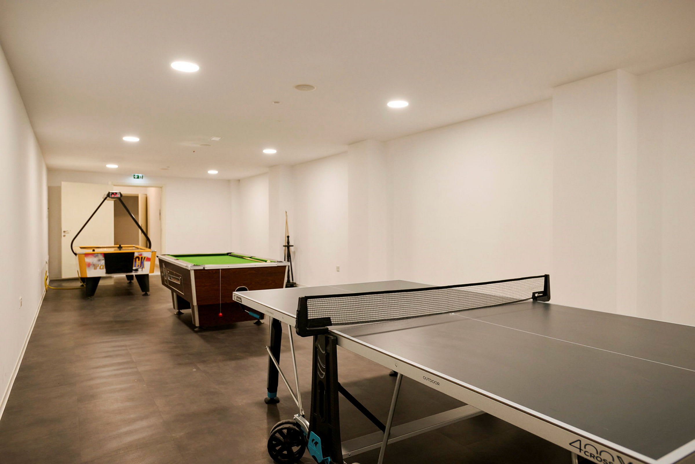 Et spillrom med bordtennis, biljardbord og air hockey-bord. (AI-generert tekst)