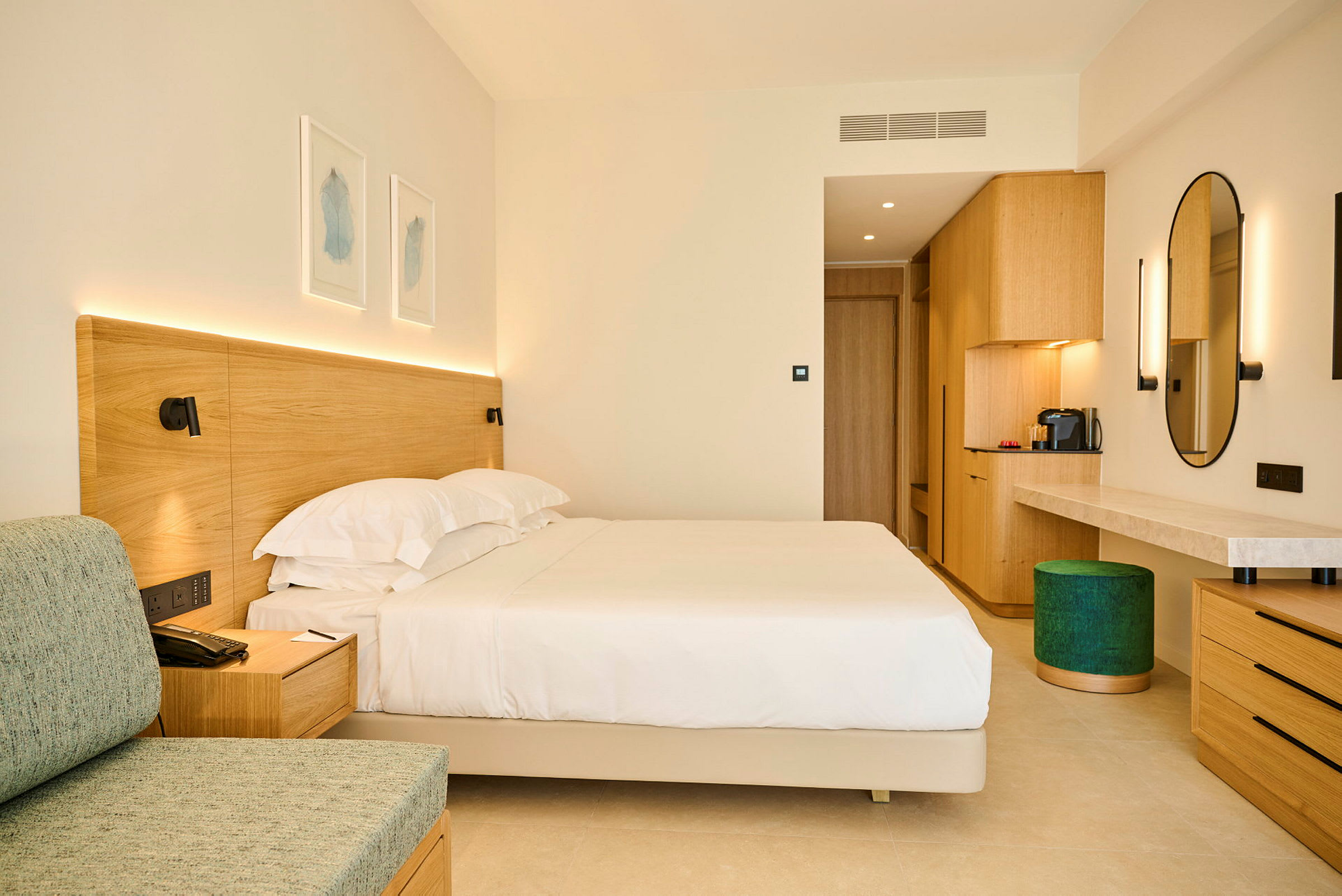 Et hotellrom med en stor seng, tremøbler og en stilfull moderne innredning. (AI-generert tekst)