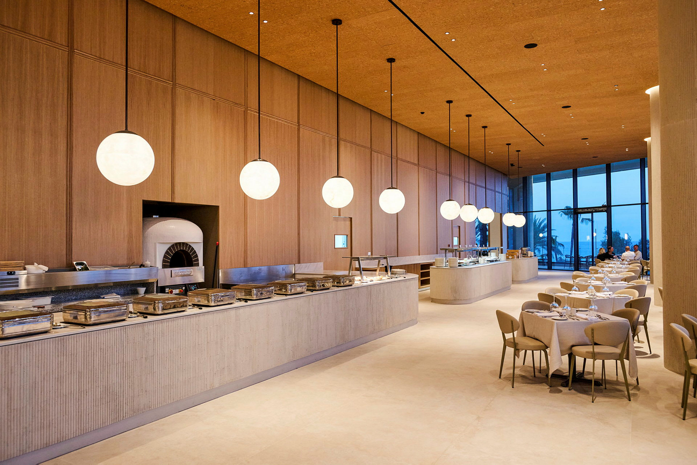 En elegant restaurant med moderne møbler, store vinduer og serveringsbord oppstilt. (AI-generert tekst)