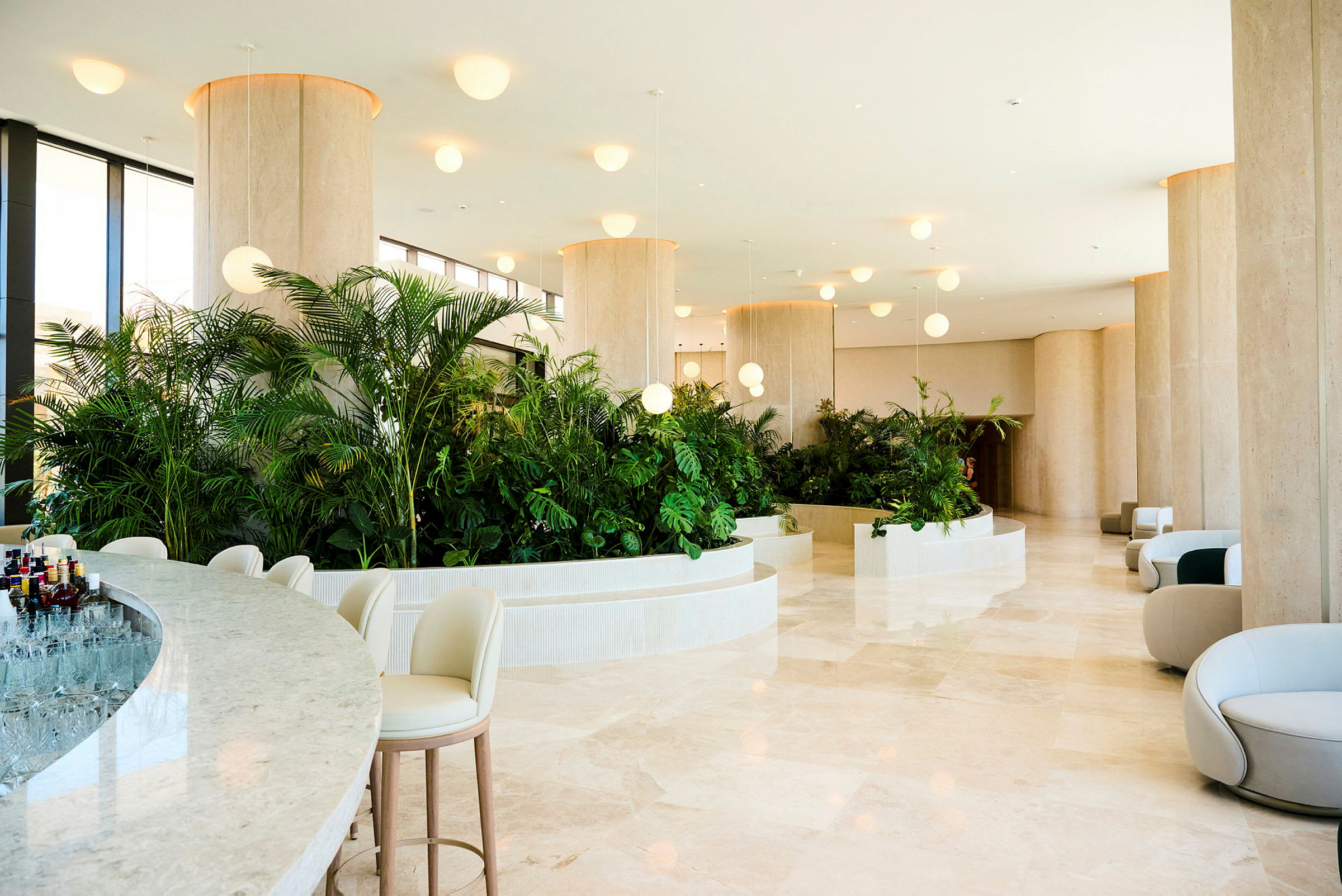 Hotellobbyen med moderne, lyse møbler og frodige planteinnslag. (AI-generert tekst)