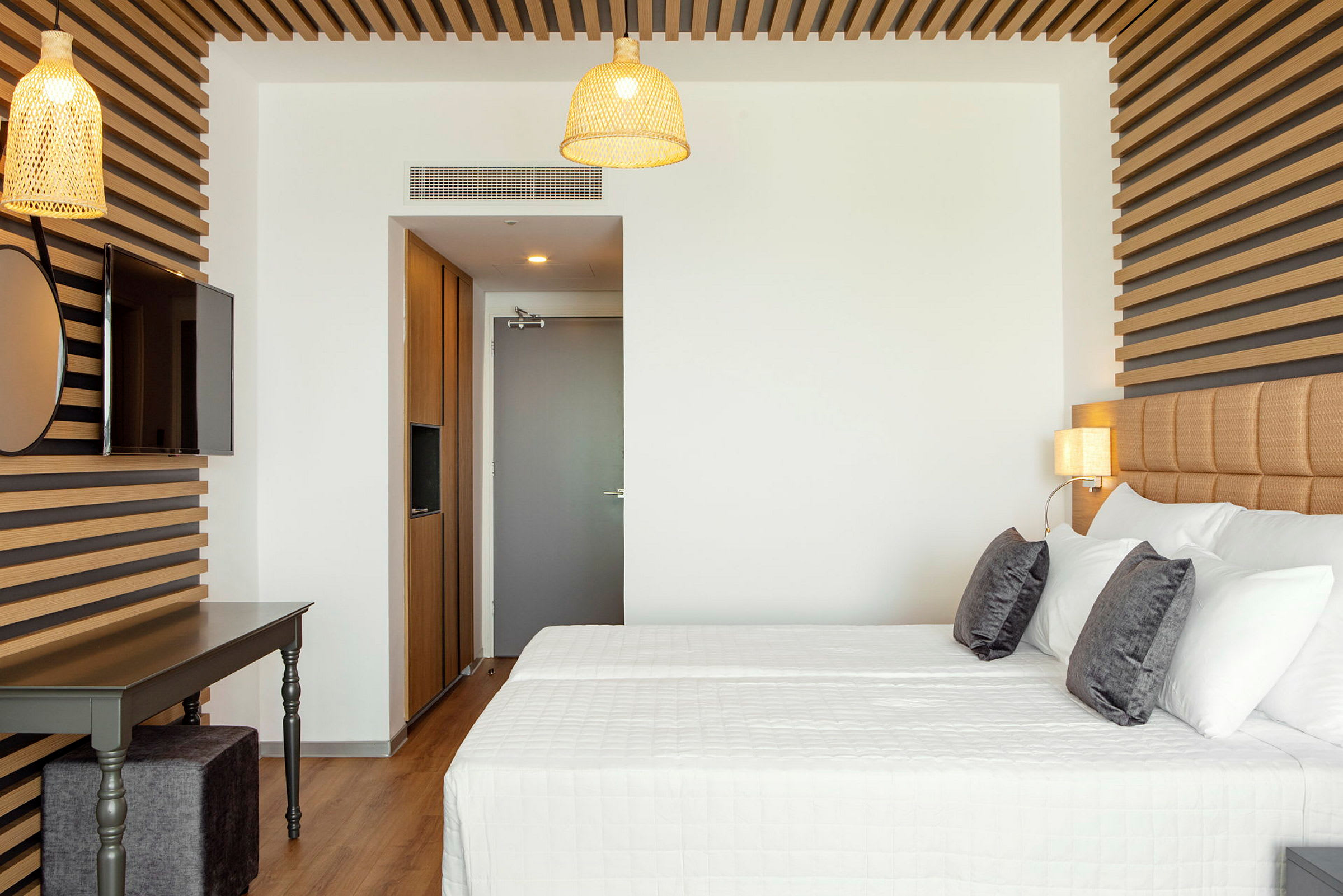 Moderne hotellrom med dobbeltseng, tredekorasjoner og lamper. (AI-generert tekst)