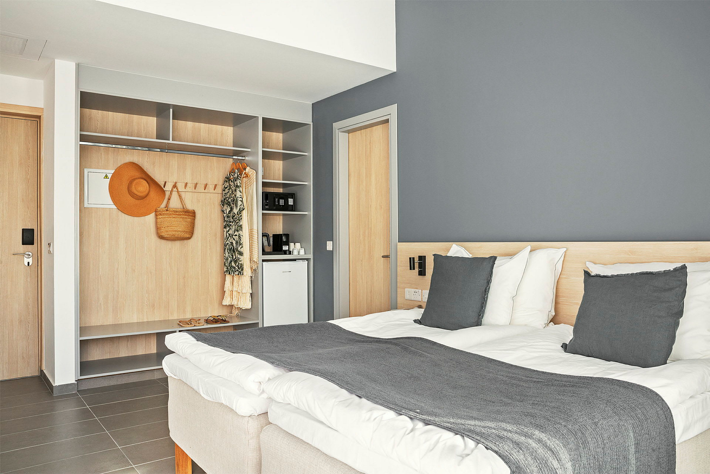 Hotellrom med en dobbeltseng, innebygd garderobe og en minibar. (AI-generert tekst)