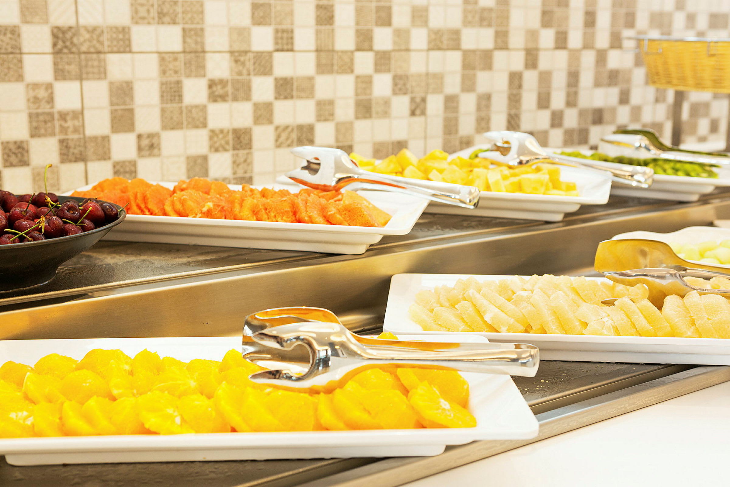 Buffet med forskjellige typer frisk frukt på serveringsfat. (AI-generert tekst)
