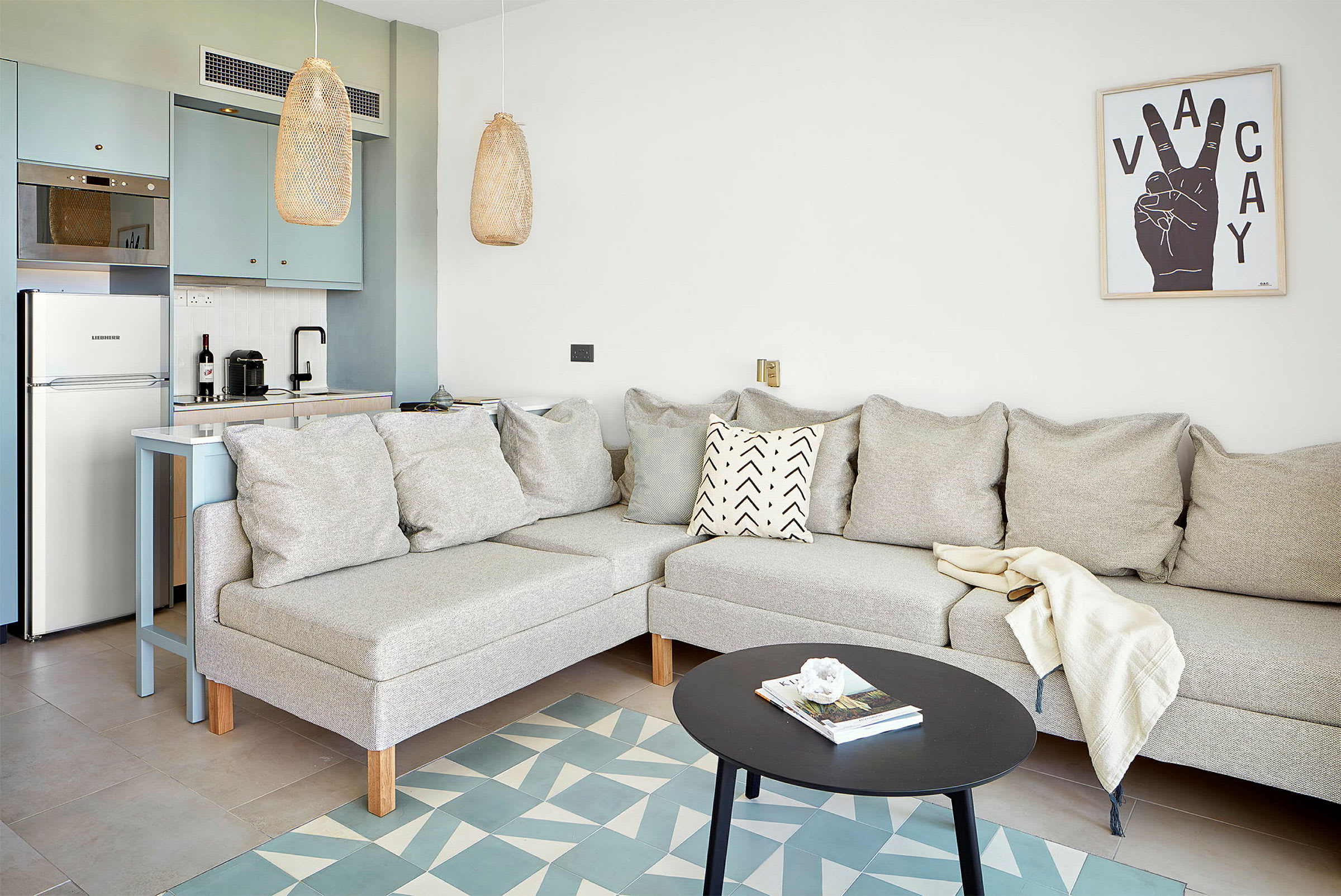 Lyst stue med sofa, sofabord og integrert kjøkken. (AI-generert tekst)
