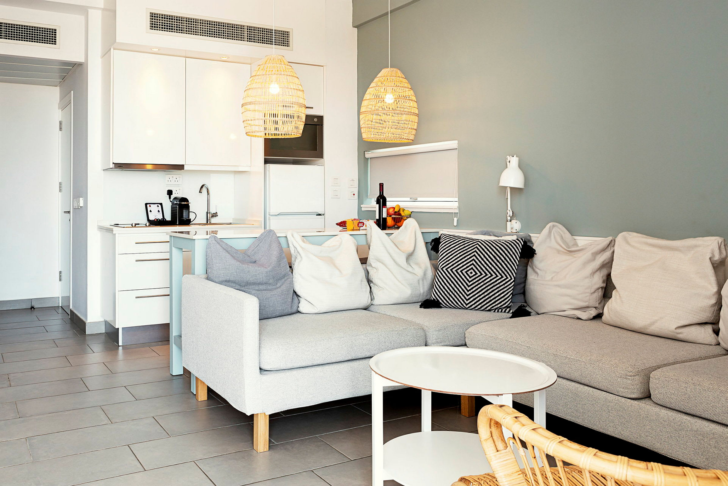 En moderne innredning med sofa, sofabord og et kjøkken i bakgrunnen. (AI-generert tekst)