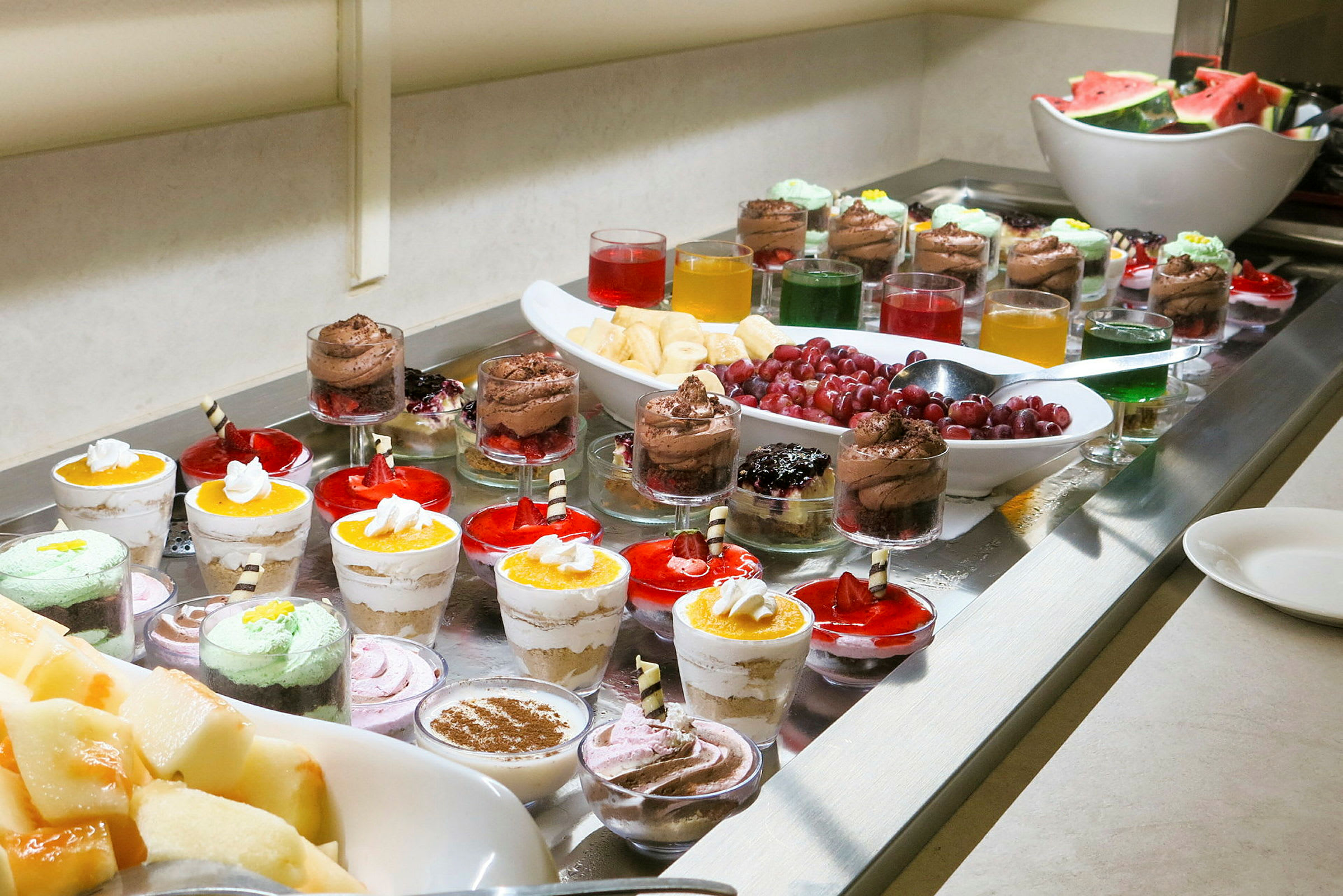 Bilde av et dessertbord med forskjellige små desserter og frukt. (AI-generert tekst)