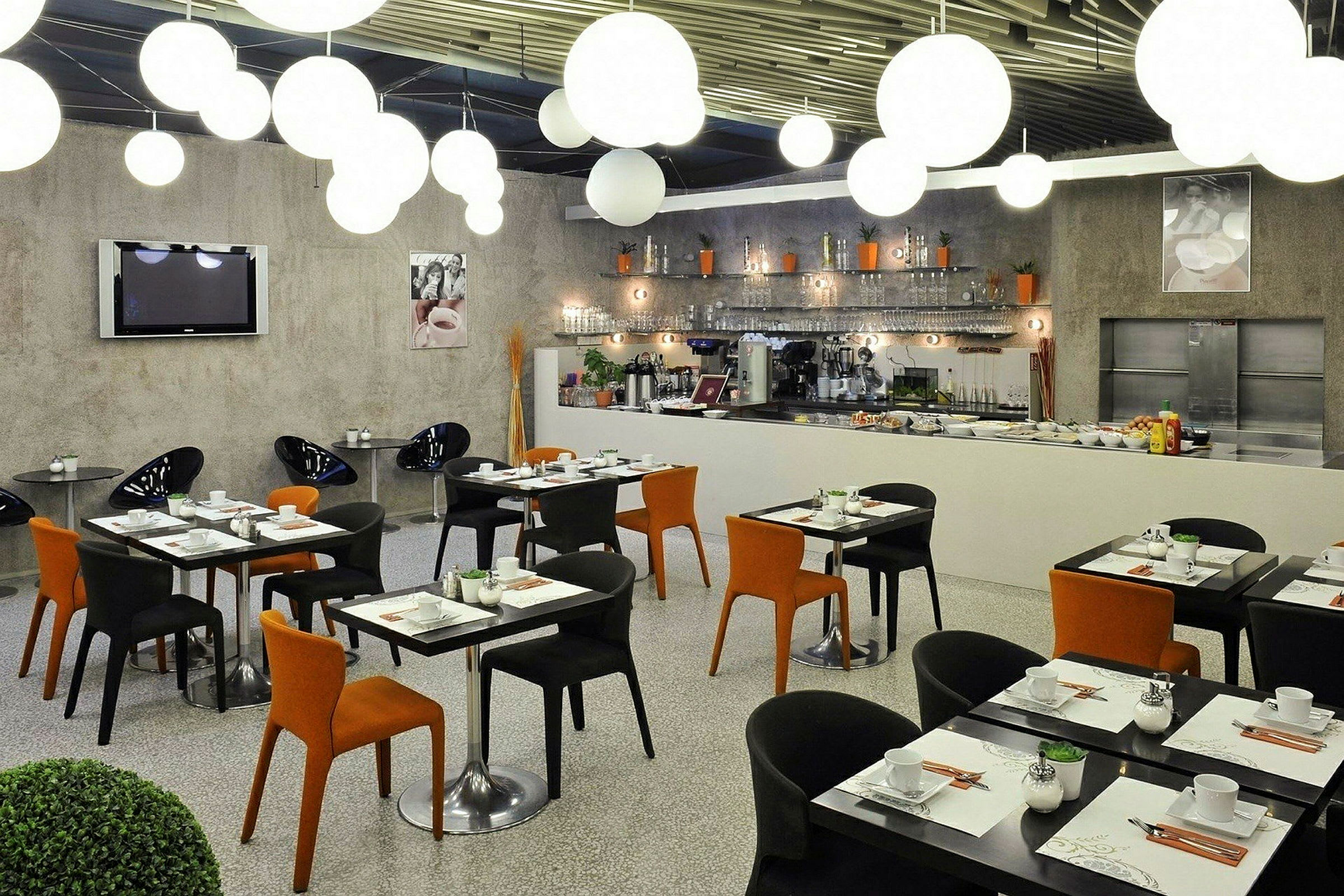 Moderne restaurantmøbler med sorte og oransje stoler samt dekte bord. (AI-generert tekst)