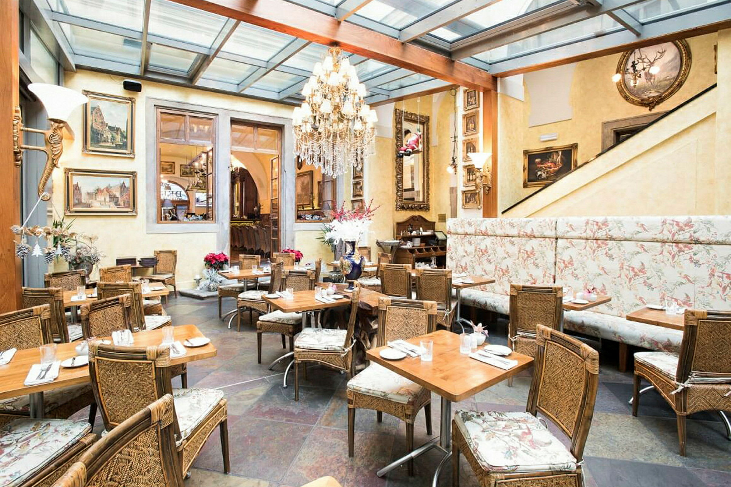Elegant innredet restaurant med panoramatak, veggmalerier og rustikke sitteplasser. (AI-generert tekst)