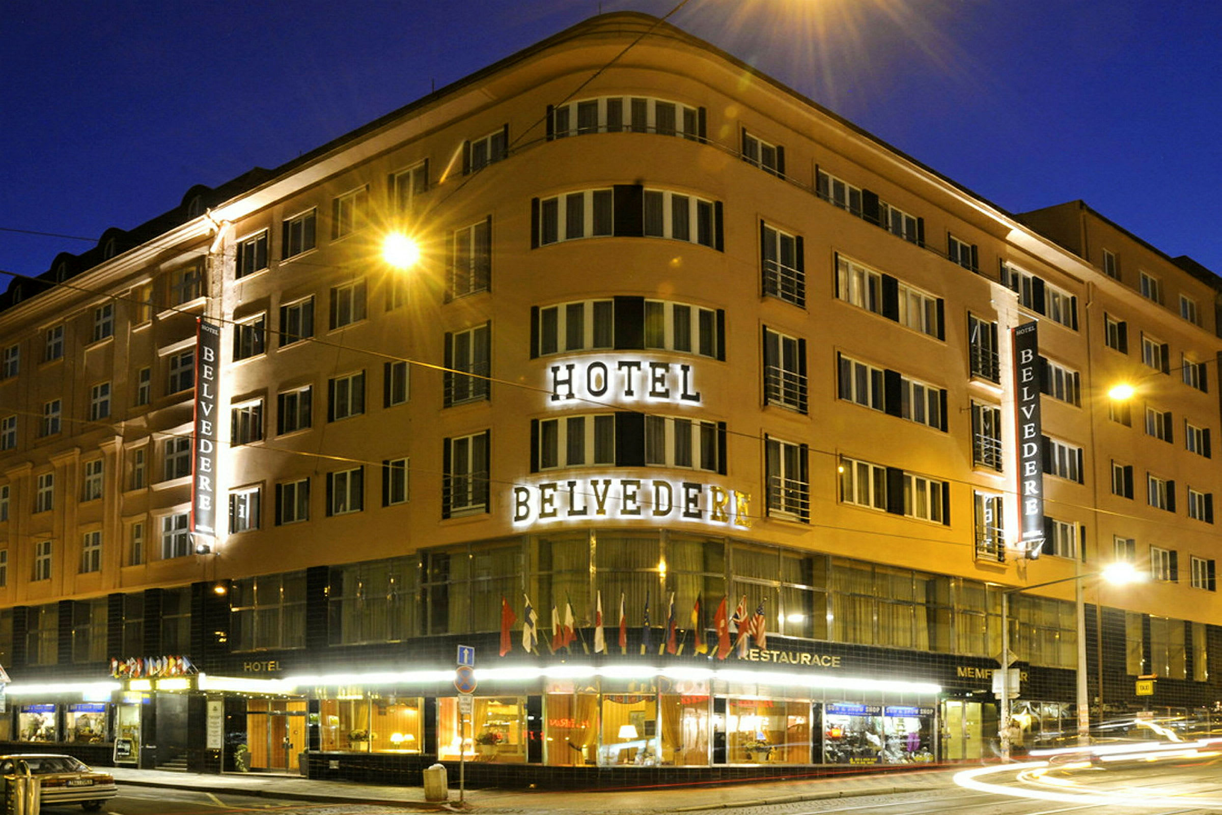 En utvendig belyst bygning om natten med teksten "Hotel Belvedere". (AI-generert tekst)