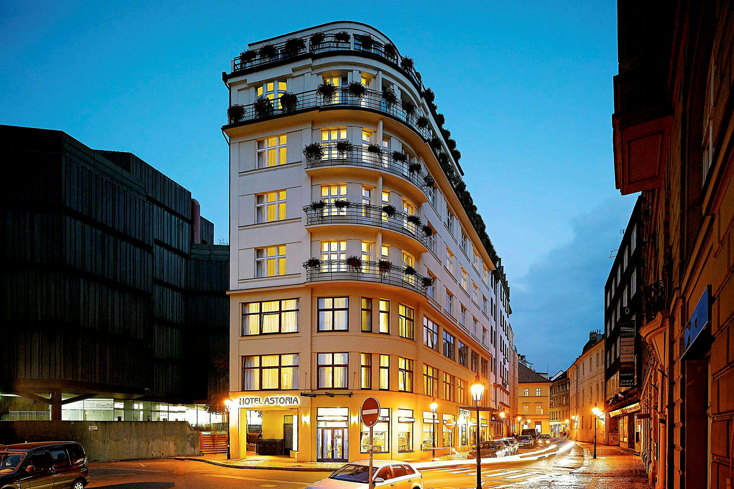 Et hotell kalt Hotel Astoria, plassert ved en veistrekning med gatelys i et bymiljø. (AI-generert tekst)